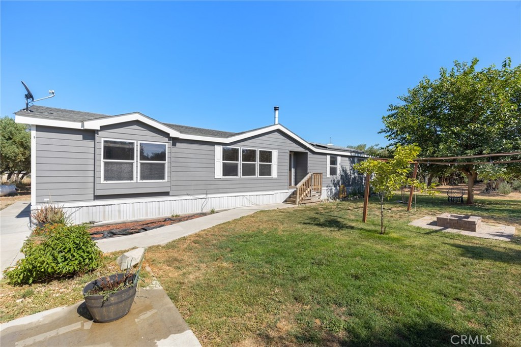 Welcome to 22695 Viola Avenue, where rural charm meets modern convenience. Situated on 2.25 acres and surrounded by an olive orchard, this 4-bedroom, 2-bath manufactured home features a spacious 1,782 square foot open floor plan. The layout is thoughtfully designed with a split floor plan—three bedrooms and a full bath on one side, and a large primary suite on the other, complete with dual vanities, a soaking tub, and a separate shower.
The main living area boasts vaulted ceilings and a cozy wood-burning fireplace, creating a warm and inviting space ideal for relaxing or entertaining. The kitchen flows seamlessly into the dining and living spaces and includes a pantry for additional storage. A full laundry room, central heating and air, and ceiling fans throughout the home provide everyday comfort and efficiency.
Solar panels help reduce energy costs, and the property also includes a storage shed and offers plenty of room for additional outbuildings, gardening, or outdoor activities.
Conveniently located near Interstate 5, this peaceful country property offers easy access for commuting while maintaining the privacy and serenity of rural living.