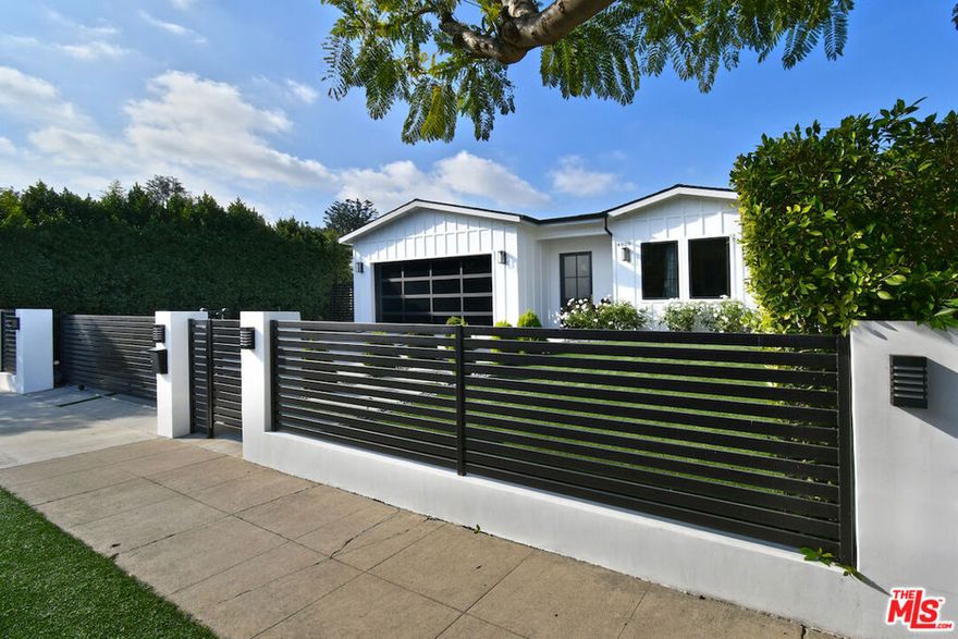 Welcome to this exceptional newer custom-built modern traditional home, designed with a focus on refined comfort and everyday ease. Located south of Ventura Blvd. behind a private gated entrance, this single-story residence features high ceilings, wide-plank hardwood floors, and an open layout that feels fresh and inviting from the moment you step into the entry foyer. The island kitchen anchors the home with custom cabinetry, a walk-in food pantry, and connection to the dining and living spaces. The formal dining area includes a built-in buffet and wine storage, offering both function and style. The adjoining living room provides a warm gathering space with built-in cabinetry, simple modern shelving, and a wood-detailed feature wall. A full wall of floor-to-ceiling sliding glass doors fills the room with natural light and opens to the backyard for easy indoor/outdoor living. All four bedrooms include their own en-suite bathrooms, and the large primary suite offers a generous retreat with a high beamed ceiling, walk-in closet, and a luxurious bath with a soaking tub and glass shower. The backyard is finished for relaxed enjoyment, complete with a heated pool and spa, patio area for dining, and a built-in BBQ island. Additional features include an indoor side-by-side laundry room and a finished two-car garage with direct entry. Thoughtful woodwork, custom hardware, and quality craftsmanship contribute to the clean, modern feel throughout. With its 2020 build/renovation, this home offers the comfort and appeal of new construction in a desirable Encino location close to shops, dining, and neighborhood amenities.