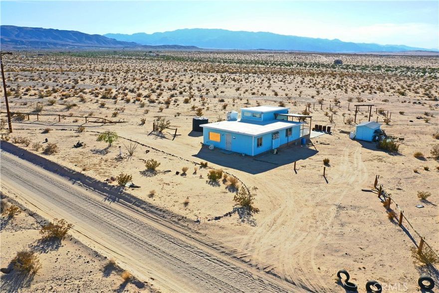 This 3-bedroom, 2-bath home sits on 5 wide-open acres with peaceful mountain views and space to build your vision. Inside, you’ll find a bright living area and a spacious primary suite with a walk-in closet, private bath, and direct access to the back porch. It’s the perfect spot to take in colorful desert sunsets or unwind under the stars.



The property has all utilities in place and runs on hauled water, with the option to install a well for added convenience. There’s plenty of room to build a garage, add a guest house, or bring the existing horse corral back to life.



Located just a short drive from town, the home offers a sense of privacy while still being close to local shops, dining, and everyday essentials. You’re also near Joshua Tree National Park, downtown Twentynine Palms, and the Marine base.



Whether you’re looking for a weekend getaway, a full-time desert home, or an investment with potential, this property gives you room to create something special.



Priced to sell. Ask about renovation loan options.