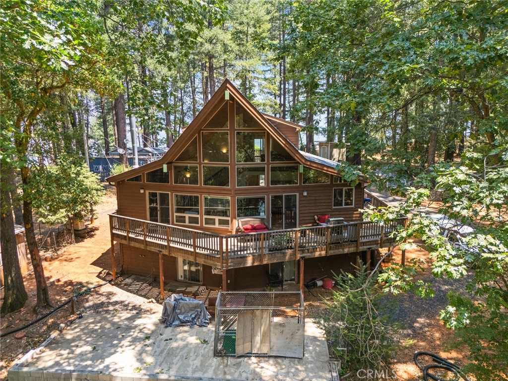 Tucked away in the stunning mountains of Oroville, yet just moments from Lake Oroville, this property offers your own private slice of paradise. Towering pine trees, sweeping valley views, and absolute peace and quiet greet you the moment you arrive. Step inside to find soaring wood-paneled ceilings, floor-to-ceiling windows framing the gorgeous natural surroundings, rich hardwood flooring, and a spacious living area complete with a cozy woodstove encased in distinctive stonework. The open-concept kitchen invites you to cook to your heart’s content, featuring warm wood cabinetry, a mix of granite and butcher block countertops, a classic farmhouse sink, sleek stainless steel appliances, and a large gas range that makes meal prep a joy. Retreat to the primary bedroom where you’ll enjoy breathtaking views, a generous walk-in closet, and a spa-like en suite with a walk-in shower. Need extra space? The lower level offers a versatile bonus area with a half bath—ideal as a guest suite, game room, home gym, or office. Additional amenities include ceiling fans throughout, two spacious guest bedrooms, an indoor laundry room, backup generator and more. Outside, relax on the expansive deck, soak up the sunshine, and breathe in the crisp pine air. Situated on 1.82 acres, the property offers multiple storage areas for your equipment and endless potential to bring your vision to life. Don’t miss your chance to own this peaceful mountain retreat!