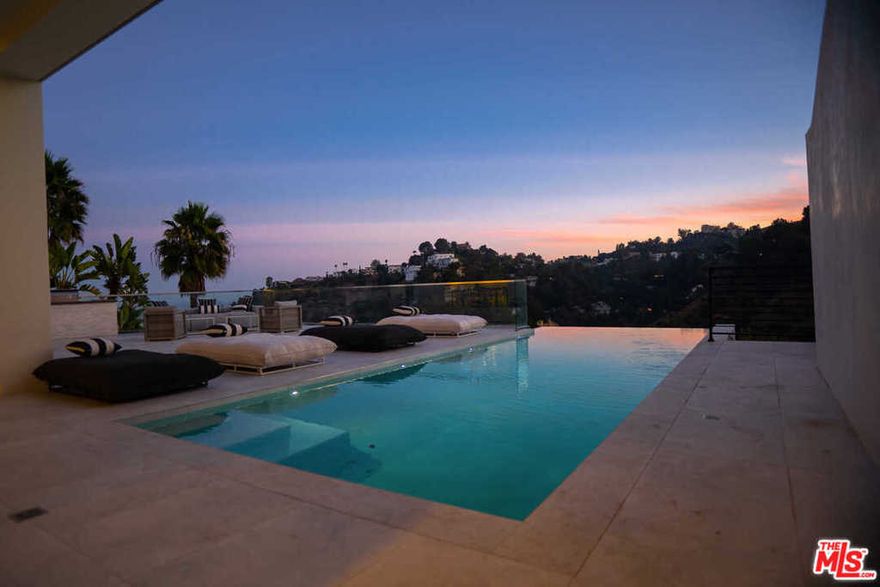 Brand new construction, this custom-built home spared no expense. Tall, voluminous spaces create a feeling a grandeur throughout the home, with large walls apt for displaying art. Fleetwood sliders and large picture windows flood the home with an abundance of natural light and frame magnificent vistas of the surrounding hills and city below. The main level includes a formal living room, dining room, built-in bar, a striking kitchen with top of the line appliances, and a the first of five bedrooms. The top level features a generous master suite with two walk-in closets and a dual terraces, plus two guest suites. The lower level entertaining area offers a proper home theater, wine cellar, media/game room, and home gym. An auto gallery replete with a turntable rounds out the interior of this beautiful home. Multiple outdoor terraces provide seamless indoor/outdoor living, including a built-in BBQ and infinity pool. Perfectly nestled above the city, minutes from everywhere you want to be.
