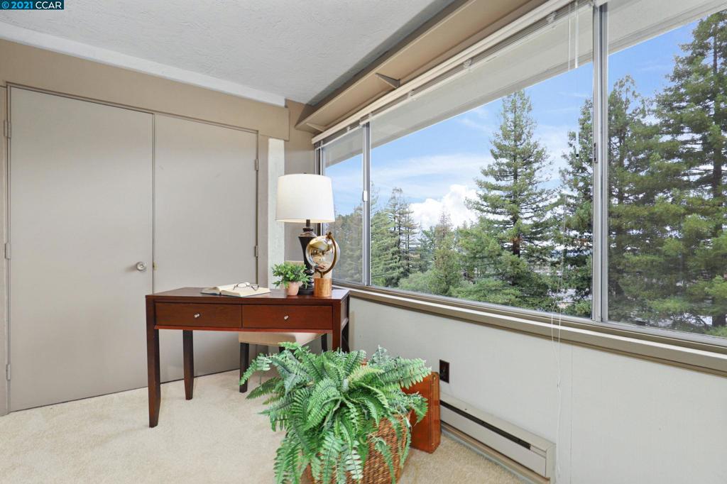 Lovely Rossmoor condo in the treetops! This charming Diablo model has a desirable open floor plan with a spacious Living Room and Dining Room combo. The light and bright Kitchen features two windows, lots of storage space and a breakfast bar. The large wrap-around balcony with serene private views has been partially enclosed giving you a great bonus interior space while still providing plenty of outdoor room from which to enjoy our wonderful Walnut Creek weather. The second bedroom is perfect for guests or a hobby room and feels private with its own bathroom right across the hall. The spacious Primary Bedroom has two updated closets and an attached bathroom with a window. The home is situated in a pleasant entry with its own little park, tons of guest parking, and the lowest monthly dues in all of Rossmoor. Carport parking with a storage closet is just steps away.