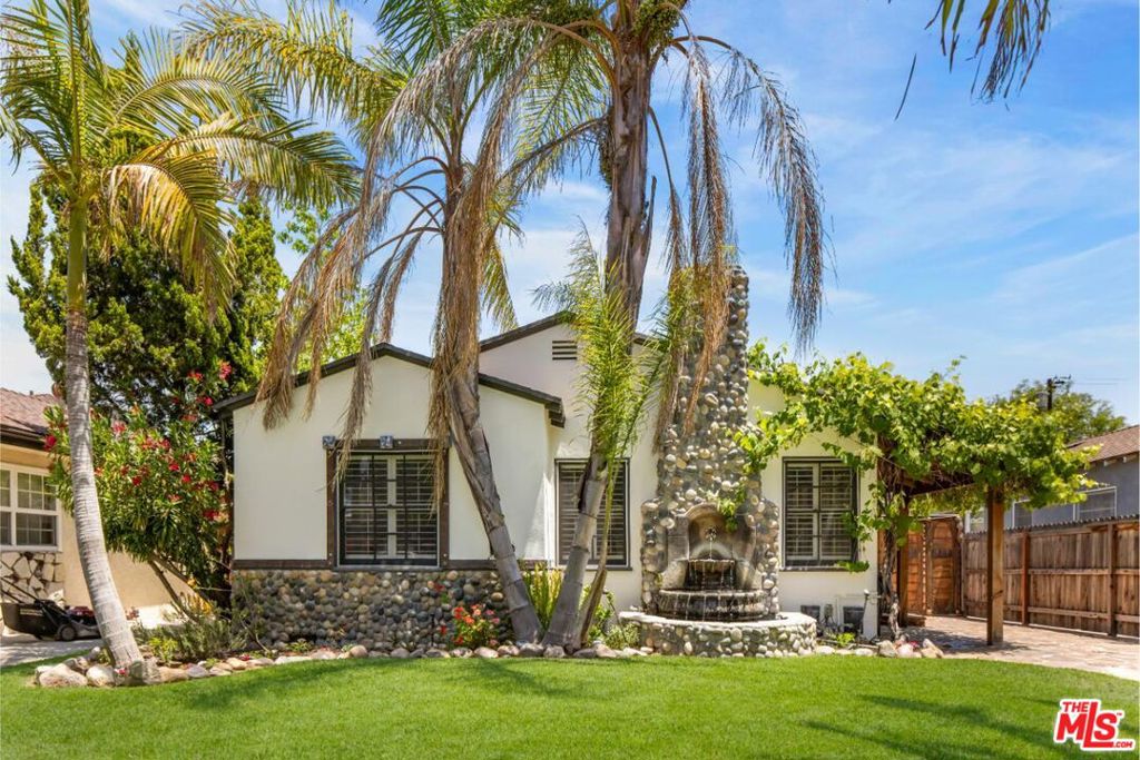Tucked into the heart of Toluca Woods, this updated traditional home with a pool and guest house is set privately on a tree-lined street. Custom millwork throughout the property adds warmth and a sense of craftsmanship, while sun-filled living spaces offer views into the backyard. The floor plan is smartly configured. The living room, with a fireplace, sits adjacent to the dining room, which connects to the kitchen and a den/flex space. The main house features two bedrooms and two bathrooms. Providing additional space for living or hosting, the detached guest house has been recently updated and is nearly 600 square feet in size. It includes a one-bedroom suite, living area, full bathroom, kitchenette with bar, and updated flooring and cabinetry. The backyard is private and well-suited for both entertaining and quiet evenings, complete with a newly installed outdoor kitchen and fire pit. The pool and spa are surrounded by mature landscaping, including a fruitful lemon tree. All this, just moments from the studios, freeways, farmers markets, and the NoHo Arts District.