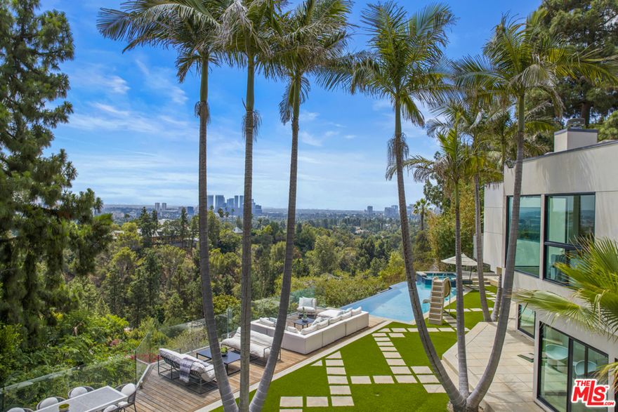 Perched on over half an acre, Loma Linda Estate is a sophisticated contemporary set on a quiet street in the heart of Beverly Hills. With striking city views from every room, the formal living area features a timeless atrium and open design that flows into the formal dining room, kitchen and two additional family rooms. The chefs kitchen is equipped to entertain, offering dual islands and Sub-Zero, Viking, and Miele appliances. With a resort-like feel and views from every vantage point, the backyard showcases an expansive grassy area, infinity pool, spa, and built-in barbecue on an oversized deck. Offering seclusion and grand scale, this property is the epitome of Beverly Hills living.
