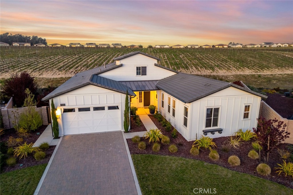 Flawless design. Urban vibe. A rare find. This nearly-new Carmel home has been artfully elevated to the next level. Beautifully situated deep within a cul-de-sac on an incredible pie-shaped lot and surrounded by vineyards and masterfully designed California native landscaping. It’s one of the most highly-sought-after models with 3 bedrooms, 3.5 bathrooms, including a casita. Built in 2021, at 2838 sq. ft., this meticulously curated modern home features a great room, dining space and a gathering space with dual sided fireplace, shared with the den (currently an audio lounge with a moody vibe), and includes luxury engineered wood flooring, high-end contemporary custom light fixtures and mirrors, granite countertops, black Shaker-style cabinetry, and a rolling wall of glass so you can enjoy the view to its fullest extent. The kitchen is striking in all black - turn off the lights at night and the kitchen magically disappears into the shadows, making the great room much more intimate and inviting. Chefs and bakers will love the GE Profile stainless appliances including a 5-burner gas cooktop, double wall ovens, honed granite countertops and island with gorgeous pendant lighting. Adjacent, you’ll find the spacious laundry and a walk-in pantry. Entertaining couldn’t be easier, just slide open the wall of glass for a seamless indoor/outdoor experience, and enjoy the incredible view. The backyard offers an extended patio with a sleek built-in fire pit, two massive side yards and two raised garden beds, all in a natural setting with drip irrigation and a decidedly zen feel. Your private owner’s suite includes a spacious bedroom and luxury spa retreat with an amazing self-watering living wall, Roman tub, separate tiled shower with seamless glass enclosure, dual sinks with vanity, quartz counters, custom mirrors and lighting, linen storage and an outfitted walk-in closet. When friends and family stay over there’s a guest room with en-suite bath featuring specialty lighting, and a casita with a living room, bedroom, linen storage and a bathroom with shower - all with the same attention to detail as the rest of the home. Additionally, there’s an exquisite powder room, solar, and a 2-car garage with tankless water heater and EV charging plug. This one-of-a-kind home is located in Trilogy with Adelina’s Bistro, Sandalwood Spa, two golf courses, and so much more.