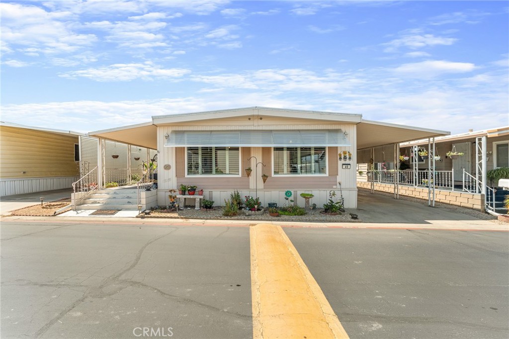 Step inside this charming and bright home located in The Colony Mobile Home Park, a fantastic 55+ community. This home features double pane windows with plantation shutters throughout, central A/C and two spacious living areas. From the front porch entry with wrought iron railing, you will find an enclosed sunroom with it's own private entry. Inside, the front living room flows into the quaint dining room with an adorable built-in cabinet and chandelier. The light & airy kitchen provides stainless steel appliances and breakfast bar. A second living space leaves room for a small home office or gym space. The primary bedroom offers an elegant primary bathroom boasting plenty of counter space! Enjoy indoor laundry which leads to the carport for effortless accessibility. This property has many established plants & flowers, with an open backyard area perfect for entertaining and enjoying nature!