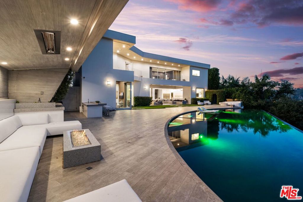 *** Seller Finance available *** Indulge in the epitome of ultra-elegance and chic design with this luxurious contemporary home situated in the elite enclave of Bel Air. Every inch of this stunning property has been meticulously designed and renovated in 2014, effortlessly blending the timeless charm of the Old World with the latest in modern technology and materials. Enter through the grand foyer and be greeted by the soaring 23' ceilings that imbue the space with a sense of grandeur and sophistication. High ceilings throughout the home provide an open and airy feel, while the three exquisite staircases make a bold statement with their sleek design and masterful craftsmanship. This home is replete with incredible features that are sure to impress the most discerning buyer. An ultra-modern vacuum elevator adds both convenience and style, while the theater and office provide perfect spaces for relaxation and productivity.The state-of-the-art open floor plan of the grand kitchen and family room, complete with a breakfast nook seating for 10, provides ample space for entertaining guests. The master wing is a true retreat, featuring an extensive private outdoor covered patio, a cozy fireplace, his and her master baths, and closets fit for royalty. Step outside to an outdoor oasis, complete with a 70' quartz infinity pool that spills into a picture-perfect view. The remote-controlled disappearing walls of glass seamlessly join the outdoor living rooms and patios with the decadent grand rooms inside, creating a seamless flow for indoor-outdoor entertaining. The gated circular motor court can accommodate up to 10 cars, with an oversized 3-car garage for added convenience. The property is extremely private and offers endless breathtaking mountaintop views, making it the ultimate in luxurious living. This is a rare opportunity to experience the pinnacle of ultra-elegance and style in the heart of Bel Air.