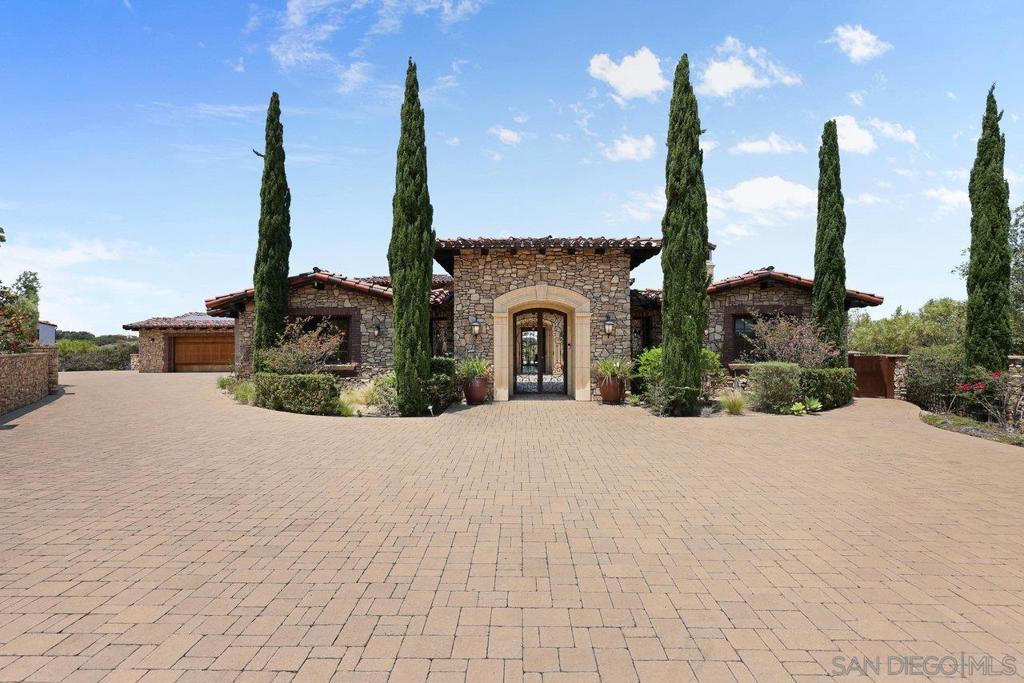 Nestled within the exclusive, guard-gated Santaluz community, this Tuscan Farmhouse redefines luxury living. Built in 2014 with craftsmanship and the highest quality materials, this impressive single-level estate seamlessly blends old-world charm with modern elegance and smart home technology. Designed for both everyday relaxation and grand entertaining, the residence features a beautiful great room, an additional family/flex room, a gourmet chef's kitchen, an in-home office, a casita, three guest suites, and a five-star primary retreat. The beauty of this estate extends beyond its exquisite aesthetics; it was meticulously constructed to exceed the highest earthquake and structural standards, stone retaining walls, a structural steel I-beam (spanning the formal great room), conventional framing, and a stone exterior. The beautifully designed, resort-inspired saltwater swimming pool and spa are perfect for enjoyment and entertaining. The pool area includes an oversized 18” deep sun shelf with two in-pool umbrella stands for shade, and a 60-foot lap and play pool with an infinity edge overlooking the protected rimmed canyon. The entire pool system is operated by top-rated equipment and smart-controlled functionality. Completing the outdoor oasis is an outdoor kitchen with a BBQ, warming drawer, and mini-fridge. Living in Santaluz offers an unparalleled lifestyle. This upscale, 24/7 guard gated community provides residents with a wealth of world-class amenities and a strong sense of community. Smart Home Technology & Systems Integrated Crestron System: Effortlessly control audio, video, and security systems throughout the entire home and outdoor spaces using wireless smart devices or in-wall master control panels in the kitchen and master retreat. Whole Home Security: Features a comprehensive security system Lutron (Vantage) Lighting System: Customize lighting moods and scenes throughout the property with "one-touch" control or manage each room independently. HVAC System: Integrated with Nest and a whole-home electronic HVAC ventilation system, featuring three separate furnaces/condensers. Control the entire system or individual rooms with a smart device or in-wall units for optimized comfort and energy efficiency. Plumbing System: Three independent tankless water heating systems with pumps for hot water. The home features a full home water filtration system, while a secondary kitchen system provides purified drinking water and instant hot water. The Chef's Kitchen is a true culinary dream, perfect for daily living and entertaining: Wolf 60” range with double ovens, 6 burners, and a large griddle, warming drawer, steam oven, and microwave. Sub-Zero dual 48” refrigerator and freezer, under-counter wine fridge. Two Bosch dishwashers. Thermador Latte/Coffee/Espresso bar. Massive prep and eat-in island with granite slab countertops and double DuPont edges, custom cabinetry, large butler's pantry with an oversized walk-in pantry, wired for a second fridge/freezer. Luxurious Finishes & Features: Flooring: Marbol stone floors throughout the great room, kitchen, formal great room, and main hallways. Hardwood floors in the master retreat, master bonus/office/nursery, and executive office. Carpet with dual pad in all secondary bedrooms and the casita. Tumbled travertine on all floors and walls in baths. Stone Wall Finishes: Volcanic Venetian Stone from Cappadocia, Turkey, used throughout, including a hand-chiseled Venetian Stone fireplace mantel in the formal great room. Tuscan brick accents throughout the home. All exterior elevations and walls clad in Eldorado Stone, Tuscan Brick, and forged Capstone. Master Bath: Appointed like a five-star resort spa, featuring his-and-her toilets (plus bidet for her), 2 walk-in closets, dual sinks with vanity, a 72x42 air-jet relaxation tub, and a huge walk-in steam/jetted/rain shower. Resort-Style Outdoor Living: The beautifully designed, resort-inspired saltwater swimming pool and spa a...