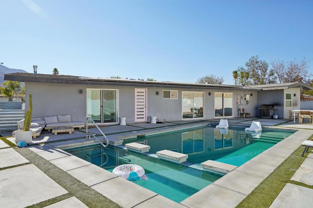 Fully remodeled and TURN-KEY, this vibrant mid-century home is move-in ready and waiting for you to start living the Palm Springs dream! Tucked away at the end of a quiet cul-de-sac and just minutes from the excitement of Downtown Palm Springs, this ultra-chic, fully updated 4 bedroom, 2 bath, 1,750 SF home with a full solar power system, it is the ultimate desert retreat--and an incredible SHORT TERM RENTAL opportunity! Set on a massive west-facing lot with stunning San Jacinto Mountain views, this property is designed to impress inside and out. The backyard is a true oasis, complete with a sparkling heated saltwater pool and spa, built-in BBQ, ample poolside seating, and a private fire pit--perfect for unforgettable gatherings under the desert sky. Step inside to sleek, modern design blended with rich textures and nods to the home's original mid-century roots, now refreshed with all-new amenities for today's lifestyle. The chef's kitchen is a showstopper, featuring high-end stainless steel appliances, a spacious eat-at island/bar, and an open flow into the great room--ideal for entertaining. Each bedroom is stylishly designed and filled with natural light, creating warm and inviting spaces throughout the home. The expansive primary suite is a true retreat, featuring direct access to the pool, a sleek wall-mounted fireplace for a cozy ambiance, and a show-stopping en-suite bath. The bathroom is finished with modern, high-end details, including a seamless walk-in shower with floor-to-ceiling tile, penny round tile floor, a wall-mounted toilet, and polished chrome fixtures--delivering both luxury and sophistication. With peak season rental rates around $450 per night, this property isn't just a home, it's a lucrative investment opportunity and a dream vacation destination all in one. Whether you're looking for a high-performing short-term rental, a desert getaway, or a stylish year-round residence, this Palm Springs stunner checks every box!