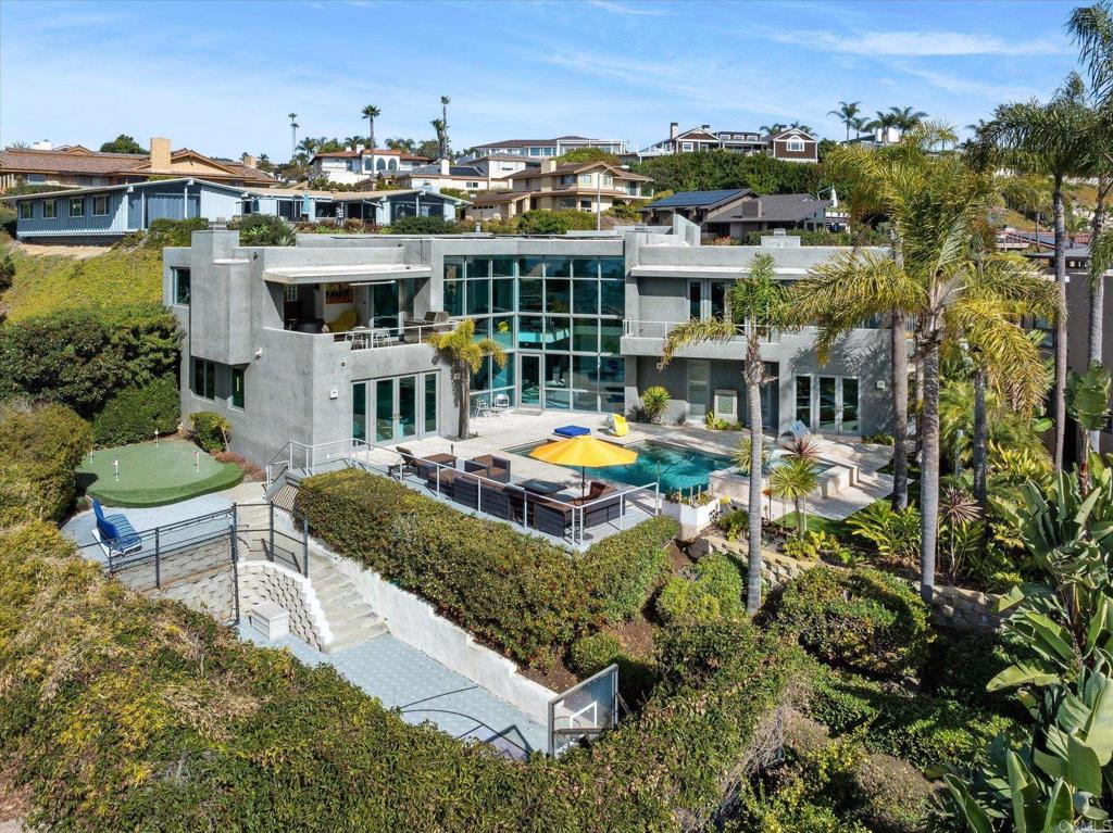 Discover the exquisite allure of 5490 Rutgers Rd in La Jolla, where contemporary architecture meets breathtaking ocean views at a unique site that faces to both the south and west. This exceptional 4BR/5.5BA residence with bonus rooms including a gym and office boasts an ideal floorplan, with the main living areas, gourmet kitchen, and luxurious primary suite conveniently located on the entry level. Step into a dramatic two-story atrium, flooded with natural light and adorned with floor-to-ceiling windows that instantly draw your gaze to the stunning ocean panorama. The expansive primary suite, open living and dining rooms, and beautifully appointed kitchen all seamlessly embrace these incredible vistas. Even the inviting downstairs family room and pool area offer captivating views of the horizon, twinkling evening lights, and downtown, all while ensuring complete privacy. The master closet is massive and the adjacent bath has its own private ocean view balcony. This luxury home is designed for those who appreciate the finer things in life, featuring wine storage, dedicated office, gym, and spacious 2-plus car garage. Additionally, a separate guest or nanny suite complete with access to a full pool bath enhances the home's versatility. Indulge in outdoor leisure with a sports court, putting green, built-in fire pit in the welcoming entry courtyard, and an array of architecturally striking design elements that provide the perfect backdrop for showcasing a large art collection. The tranquil location, exceptional quality, thoughtful layout, and remarkable features of this home create a truly magical lifestyle that is rarely found.