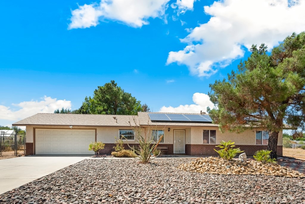 Expansive 19,000 sq ft lot with RV parking, sunroom, and low-maintenance outdoor living! This charming single-story home offers a spacious layout and fantastic amenities both inside and out. The huge backyard includes a covered RV parking area, storage shed, and deck—perfect for entertaining or enjoying quiet evenings outdoors. Inside, the living room impresses with a vaulted ceiling, brick-surround fireplace, and abundant natural light. The open kitchen and dining area feature granite countertops and direct flow to the enclosed sunroom, creating versatile living and entertaining spaces. Down the hallway, you’ll find 3 bedrooms and 2 bathrooms, including a primary suite with its own en suite bathroom. Additional highlights include a long driveway with extra parking, an attached 2-car garage, and beautifully designed low-maintenance hardscaping. A rare find with plenty of space both inside and out—don’t miss the opportunity to make this property yours!