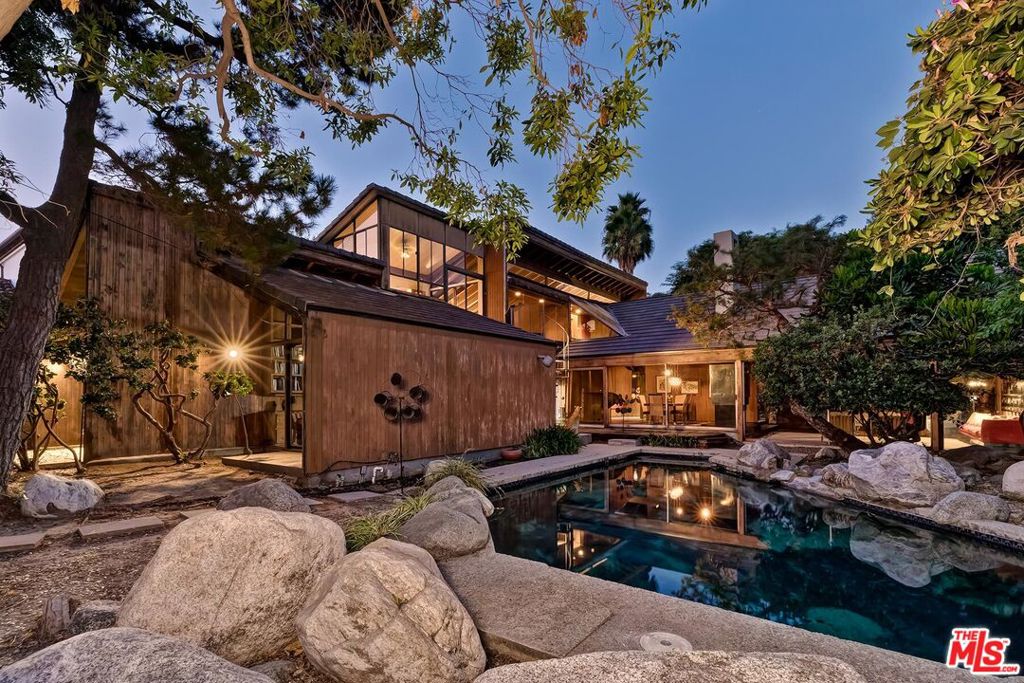 Offer deadline set for Wednesday September 25th at 7PM. Email to request the mandatory offer submission package beginning on Monday September 23rd. Certificate of Ineligibility issued by the City of Beverly Hills. Trust Sale - Sold in strictly "as is, where is" condition. Set on an 80ft wide premier westend Flats 500 block lot and available for the first time since being built by the owners in 1971, this uniquely bohemian and rustic architectural Modern with 70's "mod" curb appeal integrates the creative vibe of Laurel Canyon with the convenience of being in the Flats. Fashioned after a Japanese hunting lodge by the noted Dorman/Munselle group, this sunlit distinctively angular home is clad (interior and exterior) in cedarwood and features super high vaulted ceilings, ridge skylights, walls of glass, wood/tile floors, and a fabulous open entertainer's floor plan. Dramatic entry foyer with gallery opens to massive dining and living spaces overlooking the grounds. Spacious kitchen/breakfast area/bar/family room. The large loft-like primary suite encompasses the entire upstairs of the home and has a sizable gym/office/sauna along with extensive closet and bathroom space. Main living spaces and the two generous downstairs bedrooms all flow to the rear grounds highlighted by a six-sided polygonal pool and mature foliage. Direct-access 2 car garage for privacy and security along with a circular drive for off-street parking galore. Truly the illustration of a property with limitless potential in a coveted location moments from the finest amenities of Beverly Hills and the Westside.