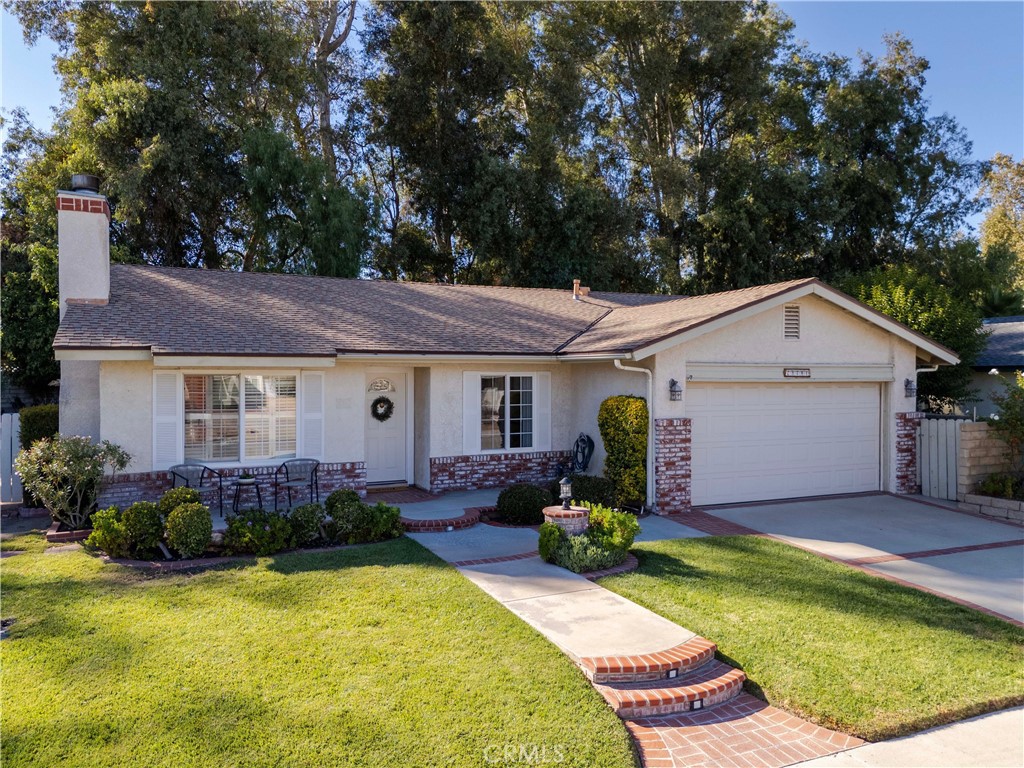 Welcome to this charming 3 bedroom 2 bath single story home tucked away on a peaceful cul de sac in the heart of Valencia. Offering 1,196 square feet of comfortable living space this lovely home boasts wonderful curb appeal. Step inside to a bright living room featuring beautiful windows bringing in natural light, vaulted ceilings, and a cozy fireplace with a beautiful mantel perfect for relaxing evenings. The separate dining area opens to a well-designed kitchen with granite countertops, ample cabinetry, breakfast nook, and a functional layout ideal for everyday living. Down the hall, you will find one bedroom (currently used as an office), second bedroom, and a full bathroom. The spacious primary bedroom includes a large closet, and sliding door leading to a patio area, and an en suite bath with walk-in shower for added convenience. Additional highlights include newer dual-pane windows, plantation shutters, ceiling fans, and 2 car direct access garage. The home also features a lovely attached sunroom, perfect for additional living or entertaining space. The private backyard includes a charming arched trellis-covered seating area, lush landscaping, planters, and a grassy area ideal for relaxing or entertaining. While already well-loved, this home offers a wonderful opportunity for a new owner to add their personal touches to make it truly shine. Perfectly situated in a highly desirable central Valencia location near College of the Canyons, CalArts, shopping, golf, restaurants, highly rated schools, and freeways. NO HOA or Mello Roos. Such a great home!