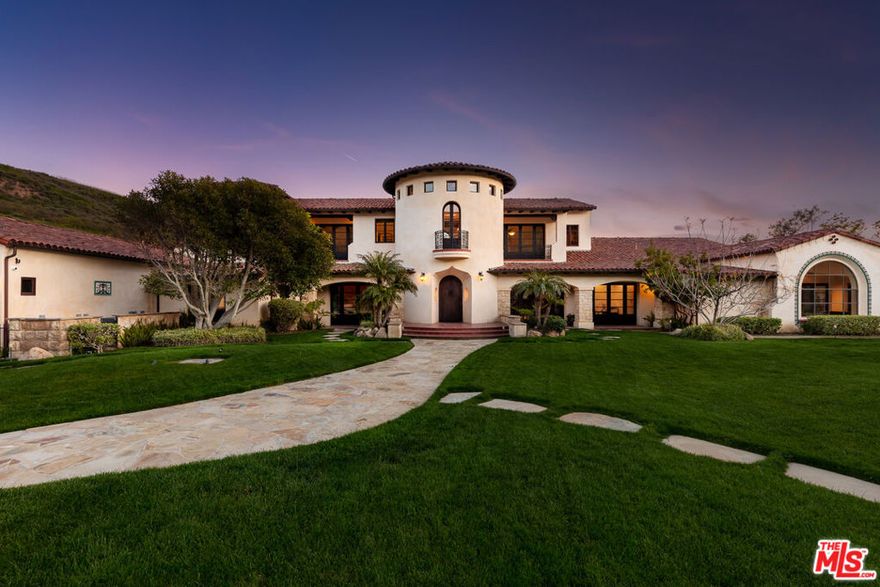 Welcome to El Palacio Del Solano, an exquisite oasis nestled within the prestigious Solano Verde Ranches. This extremely private enclave of 39 palatial estates is centrally located from Los Angeles, Malibu, & Santa Barbara. Located just 25 minutes north of Westlake Village and Thousand Oaks, and a mere 45 minutes from the pristine shores of Malibu, this secluded sanctuary offers convenience. Each of these generational estates sits on dozens of acres encompassing the most pristine natural landscapes known to Southern California. Beyond the handcrafted gates, ensconced amidst verdant fruit orchards and bordered by a meticulously manicured tree-lined driveway, awaits a truly unparalleled residence, the holy grail of Somis. Spanning 22 acres of secluded splendor, this Spanish palatial estate exemplifies opulence at every turn. Boasting approximately 20,000 square feet of meticulously designed living space, the estate epitomizes grandeur & opulence. The centerpiece is the magnificent 14,460 square foot main residence, complemented by a fully appointed 2,300 square foot guest house and an expansive 3,100 square foot hospitality and recreational facility. Step inside and be greeted by perfectly detailed Spanish tiles along the flooring and an all encompassing floor to ceiling window. From the state-of-the-art media room to the tranquil library & private office, each space exudes sophistication. Culinary delights await in the gourmet kitchen ideal for large gatherings, while the bar and wine cellar beckon for evenings of refined entertainment. Retreat to the sumptuous master suite, where a private primary living room is joined with a double-sided fireplace. The dual primary bathrooms feature a spacious dressing area, sauna, double-sided glass enclosed shower, & direct access to personal gym & office. Other notable interiors include a private massage room, arcade room, and grand formal dining room. Ascend to the second floor, where hospitality reigns supreme. Three luxurious bedroom suites, each boasting private balconies with sweeping vistas, offer unparalleled comfort. A 2nd story loft space with a bar can be found overlooking the 1st floor family room with the iconic arched window capturing the picturesque mountain views. Step into the backyard where paradise awaits. A massive grass field is accompanied by multiple lounging areas and a one-of-a-kind lazy pool with a center island fire pit. The backyard is adorned by a plethora of fruit trees including lemon, avocado, pomegranate, fig, & tangerine. Walking paths leading up to your own private mountain located to the East side of the estate offer the most scenic jaw dropping mountain views. French doors off the glass enclosed breakfast room open up to a private al fresco dining and living area accompanied by an outdoor kitchen. Multiple seating & entertainment areas allow for hosting of large dinner parties or smaller intimate events. Enjoy your own private sports court with its own shaded cabana. Start your mornings with a round of tennis or basketball. The guest house is situated with a two-car garage, two beds, two baths, fully equipped kitchen, living room, & breakfast nook. This private luxurious retreat is equipped with all living essentials. The recreational & hospitality facility are ideal for hosting the most upscale events. Tucked away behind the facility are two fully equipped restrooms. A spacious four-car garage is attached to the facility equipped with volume ceilings ideal for parking event vans, trucks, and small to mid-size buses. The possibilities are endless with regard to this facility. An estimated range of fifteen to twenty cars could comfortably be parked in the driveway and motor court spaces. Whether a notable family desires an ultra-private compound or a high-status celebrity seeks a serene oasis, El Palacio Del Solano offers a lifestyle unlike any other for the most discerning buyer.