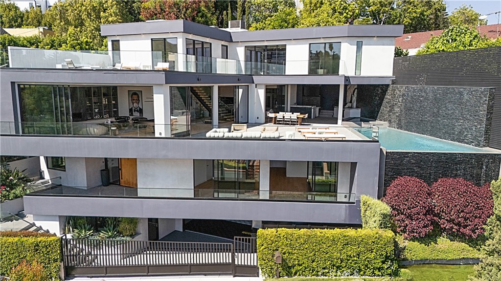Perched on a private street in the heart of the Hollywood Hills, this stunning 6-bedroom, 6.5-bathroom modern masterpiece offers the ultimate in luxury, design, and location. Built in 2022 with only one previous owner, this architectural gem combines sleek sophistication with thoughtful functionality. Located just minutes from Hollywood Blvd, Sunset Blvd, and the iconic Hollywood Bowl, yet tucked away on a quiet, no-through-traffic street, this residence delivers both convenience and privacy. Step through the oversized pivot front door to discover a lower-level entertainer’s dream: a private home theater, full bar, custom wine display, and three spacious guest bedrooms. An elevator connects all levels, from the custom 4 car garage flanked by hexagon lighting and interlocking garage tiles to the main floor where indoor outdoor living takes center stage. Floor-to-ceiling windows with hidden electronic blinds flood the home with natural light and showcase sweeping views. The gourmet kitchen is equipped with top-of-the-line Miele appliances, including a built-in coffee station, and seamlessly flows into multiple gathering spaces and the expansive outdoor entertaining deck. Outside, enjoy a luxurious spa, infinity-edge pool with waterfall, built-in BBQ, and ample lounge space—all set against the backdrop of dazzling city views. The upper level is a true primary retreat, encompassing the entire floor with a spacious bedroom, separate office or gym area, private outdoor terraces with panoramic vistas from Downtown LA to the ocean, and a resort-style bathroom featuring a massive walk-in shower with waterfall, a see-through fireplace, and a custom walk-in closet with access to a tailored patch of green- just enough to enjoy the feel of nature without the upkeep. This home is the perfect blend of cutting-edge modern design, high-end finishes, and unmatched location—an entertainer’s paradise and a private sanctuary in one. Broker and agents do not represent or guarantee the accuracy of the square footage, income, expenses, condition, development potential, bedroom/bathroom count, lot size or lot lines, dimensions, permitted or non-permitted spaces, or school eligibility. Buyer is advised to independently verify the accuracy of all information with appropriate professionals. There are no warranties or guarantees, buyer to rely solely on his/her/their own
findings.