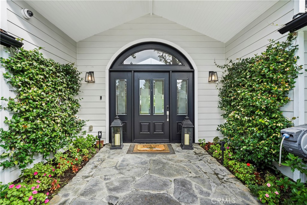 South of the Boulevard in prime Woodland Hills, this sprawling single-level estate sits gracefully on a picturesque corner lot surrounded by mature trees and manicured landscaping. Offering over 4,600 square feet of living space on nearly half an acre, the residence includes a private 1-bedroom, 1-bath guest unit complete with a full kitchen and its own entrance — ideal for extended family, guests, or a home office setup.
Inside, natural light pours through oversized windows, accentuating the vaulted ceilings, recessed lighting, and gleaming hardwood floors throughout. The heart of the home is the chef’s kitchen — a true showpiece featuring a grand center island, custom cabinetry, stainless-steel appliances, granite countertops, A-frame ceilings, and a walk-in pantry. The luxurious primary suite offers a spa-like marble bath with a soaking tub, separate glass-enclosed shower, dual vanities, and a large walk-in closet. Four additional bedrooms, a spacious family room, and formal living and dining areas provide exceptional comfort and versatility.
Outdoors, the property truly shines. Decorative wrought-iron gates and a stamped-concrete driveway welcome you into a resort-style retreat. The backyard features a sparkling gated pool and spa, multiple dining and lounging patios, and a built-in BBQ and outdoor kitchen area perfect for entertaining. Expansive grassy lawns, towering shade trees, and lush hedges create privacy and a serene atmosphere ideal for gatherings or quiet relaxation. A covered terrace transitions seamlessly from indoor to outdoor living, while a separate garden area offers space for play, pets, or raised vegetable beds. Ample parking and a generous side yard complete this exceptional offering.