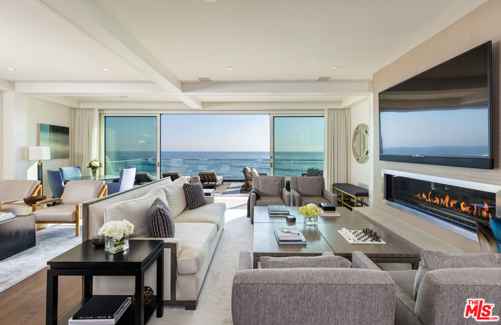 Completely reimagined & rebuilt custom home built from the sand up. This three-level home is equipped with the highest quality finishes & no expense spared. Quality construction, fully integrated Crestron smart system, & remarkable ocean views from every level. The sophisticated light-infused open-plan layout includes apx. 4,800sf of living space, 1,300sf of ocean view decks, plus a 400sf sand level entry/deck, boat house, & storage. Main level living area flows seamlessly between family room, chef's kitchen, & living room opening onto an ocean view deck spanning the width of the house. On the lower level, a large exercise suite (or bedroom) opens onto another wide deck. The upper level, with very high ceilings, has two family bedrooms, an office/den, plus the spectacular master suite, with one fireplace inside & another outside on the private ocean view deck w/hot tub. With toes in the sand on one of Malibu's most desirable beaches & prime location, this is coastal living at its best.
