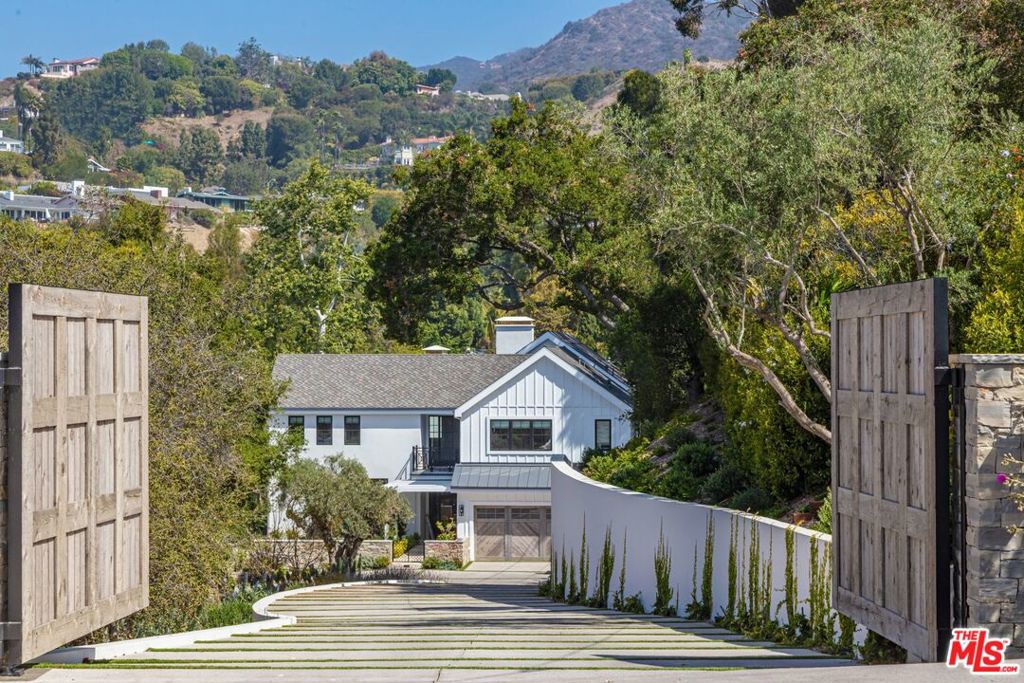 This brand new Backen-inspired contemporary farmhouse estate is a private green retreat set on a park-like acre in the Pacific Palisades, while only minutes to the beach. Behind reclaimed oak gates, a well-manicured driveway leads to the ultimate wellness & entertainment compound. Floor-to-ceiling doors throughout open onto outdoor entertaining areas featuring a 70 ft ozone lap pool, hot & cold plunges, bocce court and alfresco dining. Complete with a theater, gym, infrared sauna, & massive standalone barn guest house in the serenity of imported 50+ year old olive trees from Napa, blooming flowers, & edible gardens. This 8 bed, 11 bath beautiful home is crafted with world-class finishes such as French limestone, handmade tile, & European oak floors & beams throughout that fully harmonizes with its natural surroundings. Open, sun-kissed living spaces with high ceilings feature a living room with a double height fireplace and chefs kitchen. Upstairs house a multi-room primary suite boast