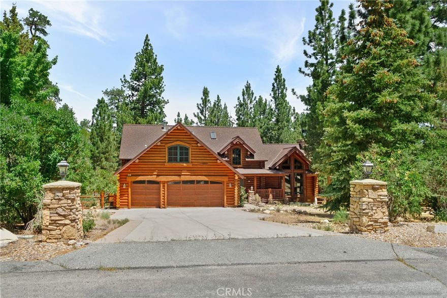 Set among the tall pine trees of Meadowbrook Estates in Big Bear City, this beautifully crafted two-story, log-style cabin offers over 3,262 square feet of living space on a spacious 1.26-acre lot. This 5-bedroom, 3.5-bathroom home is fully furnished and ready to enjoy as a full-time residence, weekend getaway, or vacation rental. A welcoming log-accented entryway opens into a warm and inviting main level that features a grand living room with soaring ceilings, expansive windows that fill the space with natural light, and a floor-to-ceiling wood-burning fireplace. The open-concept layout continues into a large kitchen, complete with granite countertops, stainless steel appliances & dual sinks. Adjacent to the kitchen is a cozy breakfast nook with bar-height seating, as well as a formal dining area that overlooks the backyard and opens to a spacious deck through sliding glass doors. The main floor also includes a generously sized primary suite with its own fireplace, jetted tub, walk-in shower, dual sinks, and walk-in closet. A half bath for guests and a separate laundry room are also located on the first floor. All main-level rooms—including the primary suite, kitchen, dining room, and living room—offer direct access to the backyard through individual exterior doors, creating a seamless indoor-outdoor connection. Upstairs, you'll find a junior suite with its own private bathroom and walk-in shower, along with three additional bedrooms that share a full guest bathroom featuring dual sinks and a standard bathtub. A generous loft area with a wet bar provides flexible space for entertaining, lounging, or game nights. Just off one of the bedrooms, there’s also a dedicated office or bonus space—ideal for working remotely or creating a quiet retreat. The home also features a spacious three-car garage and plenty of outdoor space, surrounded by tall pine trees that offer privacy and a true sense of mountain living. Whether you're entertaining, relaxing, or simply taking in the quiet natural setting, this property provides the perfect backdrop. Located just 10 to 15 minutes from Big Bear Lake, ski resorts, hiking trails, and local shops, you’ll enjoy the ideal blend of peaceful seclusion and easy access to everything Big Bear has to offer.