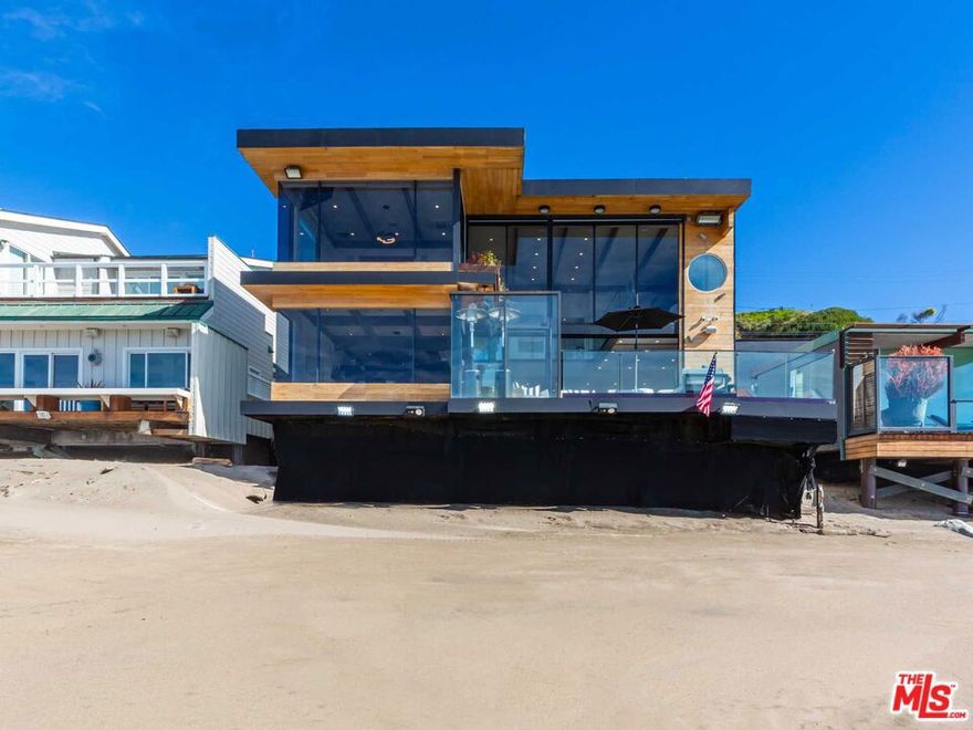 Exceptional retreat on Malibu Road, coveted for its prime beachfront location. Situated by the renowned 'waterfall rock', this home boasts a lushly landscaped courtyard entryway and expansive BBQ area. Step inside where towering walls of glass offer breathtaking ocean views. Enjoy a chef's kitchen, open-plan living with fireplace, and expansive deck leading to the best section of sand Malibu Road has to offer. Features include a state-of-the-art movie room, versatile fourth bedroom/bunkroom, and an upstairs primary suite with panoramic vistas. Completing this coastal haven is a separate studio guesthouse boasting a full kitchen, living area with fireplace, and a private entrance. Experience coastal luxury at its finest. Available for short term and summer months $80k/month.