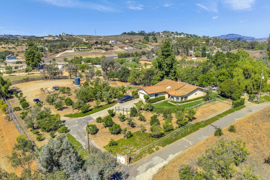Exceptional 2.67- Acre Equestrian Retreat – South Western side of Valley Center, CA Discover the perfect blend of country charm, equestrian excellence, and endless potential on this 2.67-acre horse property framed by sweeping mountain vistas. Featuring a park-like setting with large lawns, ground cover, and mature trees irrigated by a strong producing-auto timed well that sits atop an aquifer, the property offers both beauty and function. The Home, comfortable as-is with the chance to add value through cosmetic updateswith ample entertaining areas ideal for enjoying California evenings 1785 sq ft single-level residence (built 1978) with 200 sq ft bonus space: 3 bedrooms + office, 2 Bathrooms, Formal living, Family Room, Dining, Kitchen Screened in Porch and Outdoor BBQ Area Equestrian and Cow Facilities Designed with horse lovers in mind, this property is fully equipped for training, breeding, and riding: Two barns with staff quarters (ADU) for full functionality 3 oversized in-and-out stalls with soaring ceilings & natural light Excellent drainage throughout Round pen, hot walker & full arena for daily training Cattle pens for versatility in disciplines Second barn with tack room, loft, feed storage & 2 additional foaling stalls Water & Land Advantages Strong 60 GPM well with 5,000-gallon storage tank Producing orange groves for added charm and value Expansive grounds with room to expand or customize Lifestyle & Location This property combines functionality and beauty: the practicality of turn-key equestrian amenities with the serenity of panoramic mountain views. Just minutes from town yet worlds away from the bustle, it’s the perfect escape for equestrian enthusiasts, trainers, or anyone seeking the ranch lifestyle. Key Takeaway This is more than a property—it’s a lifestyle opportunity. With excellent bones, strong infrastructure, and room for your personal touch, it’s a rare South Western Valley Center location find priced for immediate action. Offered for the first time in nearly 36 years, Act Now – Don’t Miss Out on this very well priced opportunity to have it all!