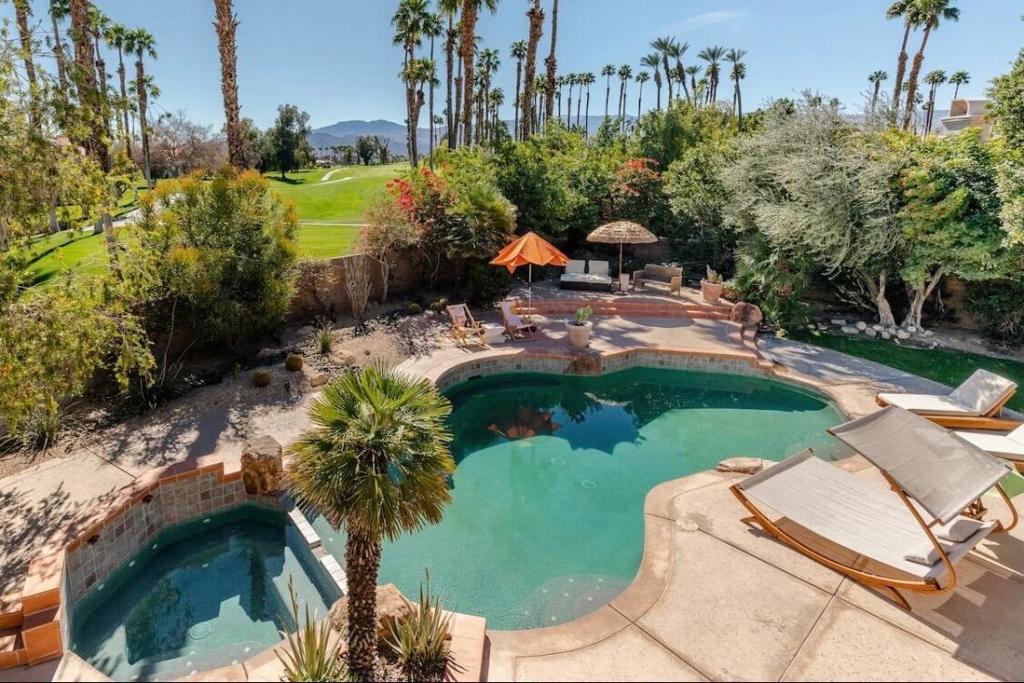 Beautifully upgraded two-story home in a desirable gated community, offering 4 bedrooms, 4.5 bathrooms, and 3,218 sq ft of refined living. Over $200,000 in custom renovations--no original fixtures remain.Features include a spacious in-law suite with its own kitchen and private entrance, polished concrete floors, and a redesigned kitchen with Samsung Bespoke appliances. Fully remodeled bathrooms, Venetian plaster accents, natural marble fireplaces, and water-efficient fixtures add to the home's elevated style.The backyard is built for indoor/outdoor living, with a new Pebble Tec saltwater pool, waterfall spillway, updated pool deck, spa, and green golf turf--your own private desert retreat.