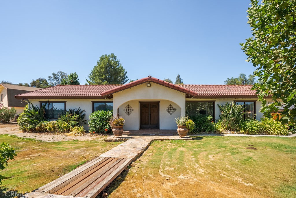 Welcome to country style tranquility just minutes from Menifee conveniences. Nestled on 1.23 acres, this well maintained 3 bedroom/2bathroom home offers nearly 1,972 sqft of living space and features that make every day feel like a getaway. Step inside to an open floorplan with formal living and dining areas, wood burning fireplace, and a bright kitchen with breakfast bar. Out back, your private oasis awaits with a pool, shaded patios, and room to relax, host bbqs, or simply unwind under the sun. With plenty of space for RVs, gardening, or animals, you'll have the freedom to live the lifestyle you've been dreaming of. The garage is converted which provides additional flexible living space. This home combines privacy, functionality, and outdoor fun- all while being minutes from shopping, schools and freeway access.