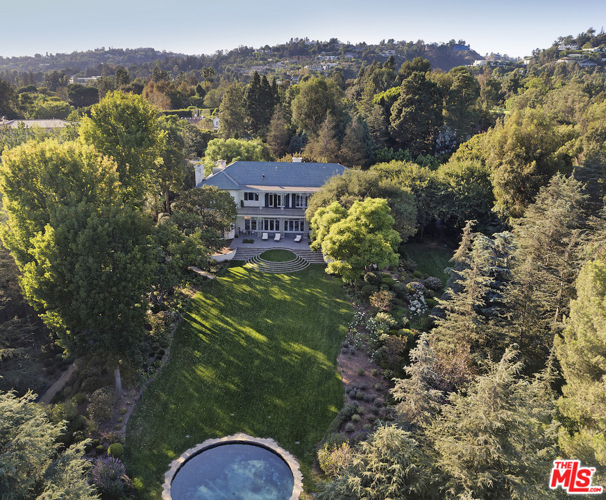 "The Edie Goetz Estate" is a trophy compound in the heart of Holmby Hills. Available for the first time in over 25 years. A magnificent example of Georgian Revival architecture originally completed in 1938 and designed by Gordon Kaufmann, classic elements include high ceilings, grand public rooms and ornate wrought iron details. In 1947, Edie Goetz engaged legendary Hollywood designer Billy Haines to enhance the main house as a showplace for lavish events. One of the most iconic rooms is the paneled art deco modern library/bar also designed by Haines. On what many consider the finest street in Los Angeles this private paradise is set behind large gates and offers complete privacy. Features of the estate include: verdant manicured grounds, pool house, swimming pool, guard house and rare specimen trees. A rare opportunity to own a piece of Hollywood history.