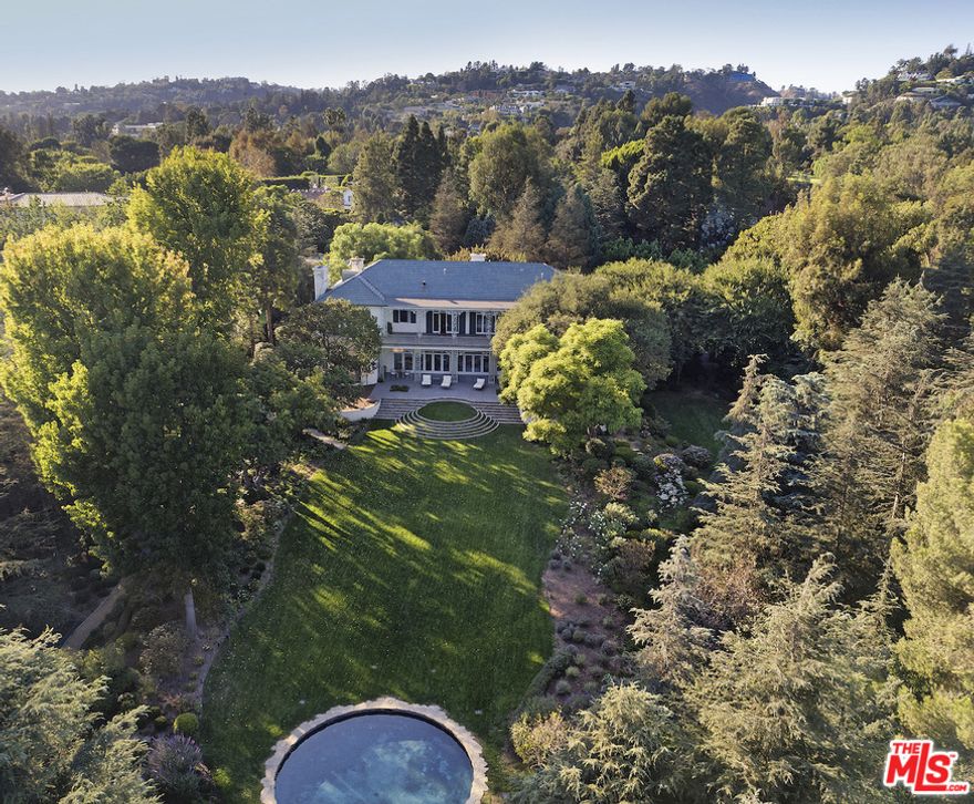 "The Edie Goetz Estate" is a trophy compound in the heart of Holmby Hills. Available for the first time in over 25 years. A magnificent example of Georgian Revival architecture originally completed in 1938 and designed by Gordon Kaufmann, classic elements include high ceilings, grand public rooms and ornate wrought iron details. In 1947, Edie Goetz engaged legendary Hollywood designer Billy Haines to enhance the main house as a showplace for lavish events. One of the most iconic rooms is the paneled art deco modern library/bar also designed by Haines. On what many consider the finest street in Los Angeles this private paradise is set behind large gates and offers complete privacy. Features of the estate include: verdant manicured grounds, pool house, swimming pool, guard house and rare specimen trees. A rare opportunity to own a piece of Hollywood history.