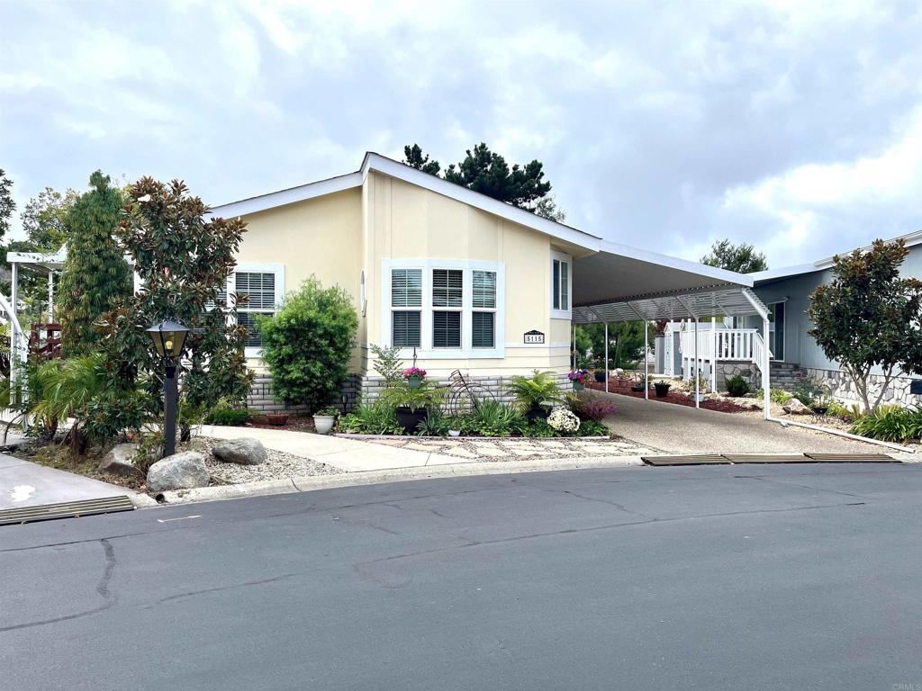 Welcome to Rancho Carlsbad, a highly sought-after 55+ guard gated & resident -owned community offering resort-style living. This beautifully maintained home offers 1,638 square feet of comfortable living space with 2 bedrooms, a den/office, & 2 full baths. Situated on one of the largest lots in the community, this home stands out with it's spacious backyard & expansive front porch- perfect for morning coffee, afternoon gatherings, or simply enjoying the peaceful surroundings. Inside, the inviting floor plan features a large family room with a cozy fireplace & an adjacent dining area ideal for entertaining. The kitchen is an entertainer's delight, complete with an island, abundant counter space and plenty of cabinetry. The oversized laundry room includes a pantry, utility sink, & even more storage. The spacious primary suite offers a walk-in closet & a generously sized en-suite bathroom featuring dual vanities & extra cabinetry. Guests will appreciate the roomy second bedroom with a large closet, while a separate den provides a flexible space for a home office or hobby room. Additional highlights include vinyl plank flooring throughout, dual-pane vinyl windows, ceiling fans, central A/C, & an ADA compliant lift at the carport for easy access. Rancho Carlsbad offers a vibrant & active lifestyle with resort-style amenities including a pool, spa, fitness center, pickleball & tennis courts, bocce ball, dog park, & more than 30 clubs & social activities. Conveniently located near shopping, fine dining, golf, & beautiful beaches, this home is the perfect blend of comfort, convenience & community. Experience the best of active senior living today!