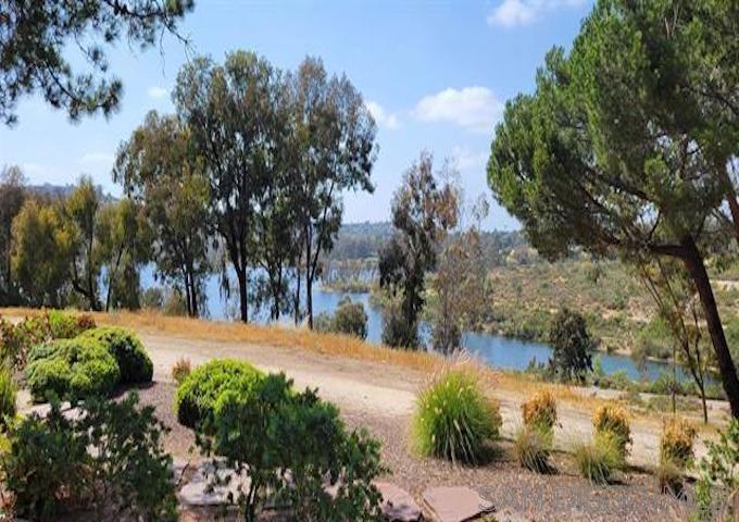 Unmatched Lakefront Location – Prime Ground-Floor Unit with Stunning Lake Views! Welcome to one of the best locations in the complex—this rare lakefront, ground-floor unit offers sweeping, unobstructed water views right from your living room, kitchen and bedroom. Step outside and enjoy the serene beauty of the lake surrounded by peaceful walking trails. Inside, you'll find stylish upgrades throughout: luxury vinyl plank flooring, quartz countertops, modern subway tiles, stainless steel appliances, closet organizers and kitchen bar seating. Cabinets have been freshly painted, and all drawers are fitted with new glides and rollers for smooth functionality. Loads of storage with a spacious kitchen pantry and a wall-to-wall linen hall closet. Bathroom features quartz counters, a sleek frameless glass shower door, and cabinet storage. Ceiling fans and a newer central AC offer year-round comfort. Other improvements include modern textured walls, recessed lighting, upgraded electrical and mirrored closet doors. Set on 24 acres of beautifully landscaped grounds, the Lake Park complex features multiple water elements including tranquil garden ponds with fountains and flowing streams. Amenities include multiple pools, spas, lighted pickleball and tennis courts, a recreation room with a billiard table, two fitness centers with showers and saunas. Ideally located near shopping, dining, miles of walking and running trails, downtown La Mesa, the popular La Mesa Farmers Market, Grossmont College, and SDSU—with easy access to Highways 8, 125, and 94. Dedicated parking is conveniently located steps from front door. Laundry rooms in each building and a short walk to the mailboxes and trash facilities. Water and trash included in HOA. Some photos are virtually staged.