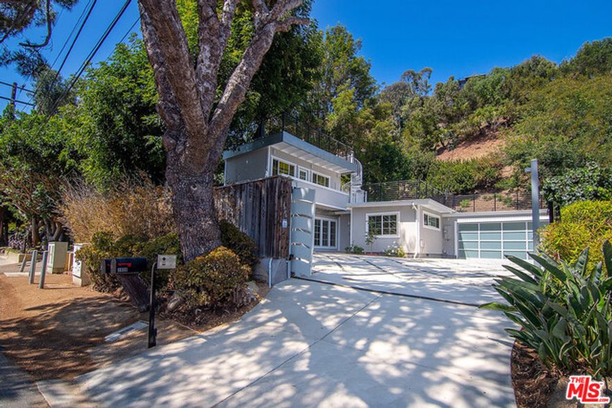 Private Malibu compound, just 1/2 block from the ocean. Completely renovated beach cottage with separate detached studio apartment, ready for immediate occupancy. Set back and privately sited above the road, this gated retreat,  just across from Las Flores Park.  Awash in sunlight courtesy of 2 remote controlled, venting skylights, the living room welcomes you with a wood burning fireplace and warm wood beamed ceiling.  French doors open to a wonderful den with a coffered ceiling and custom cabinetry. The crisply appointed kitchen, sure to inspire your inner chef and party host, features stainless steel appliances, soft close wood cabinetry with granite counters, pot filler at the stove, a cozy eat-in nook with a built-in storage bench and direct access out to a private grassy backyard, perfect for sunbathing and al fresco dining. The hotel inspired full bath features a double vanity. Secure parking for 5 cars, courtesy of the gated driveway, the super clean direct access 2 car garage (with Level 2 EV charger) and a separate carport makes this perfect for a car collector or for use as a live/work location where guest parking might be important. Other features include full capacity washer and dryer, a reverse osmosis water filter system,  tankless water heater in addition to wi-fi enabled control of the HVAC system, security system and a thoughtfully designed wi-fi enabled exterior fire suppression system. Upstairs, sited above the oversize carport is an immaculately done, jewel-box of a studio with ocean views, a full kitchen & bath and a private rooftop deck (with even bigger ocean views). Perfect as a separate office, guest house or simply additional living space. As recovery and rebuilding along the coast continues this compound could also make an ideally located interim home during any repair work or reconstruction. Malibu is a magical and resilient place. Enjoy it's best living at this wonderfully appointed slice of heaven!