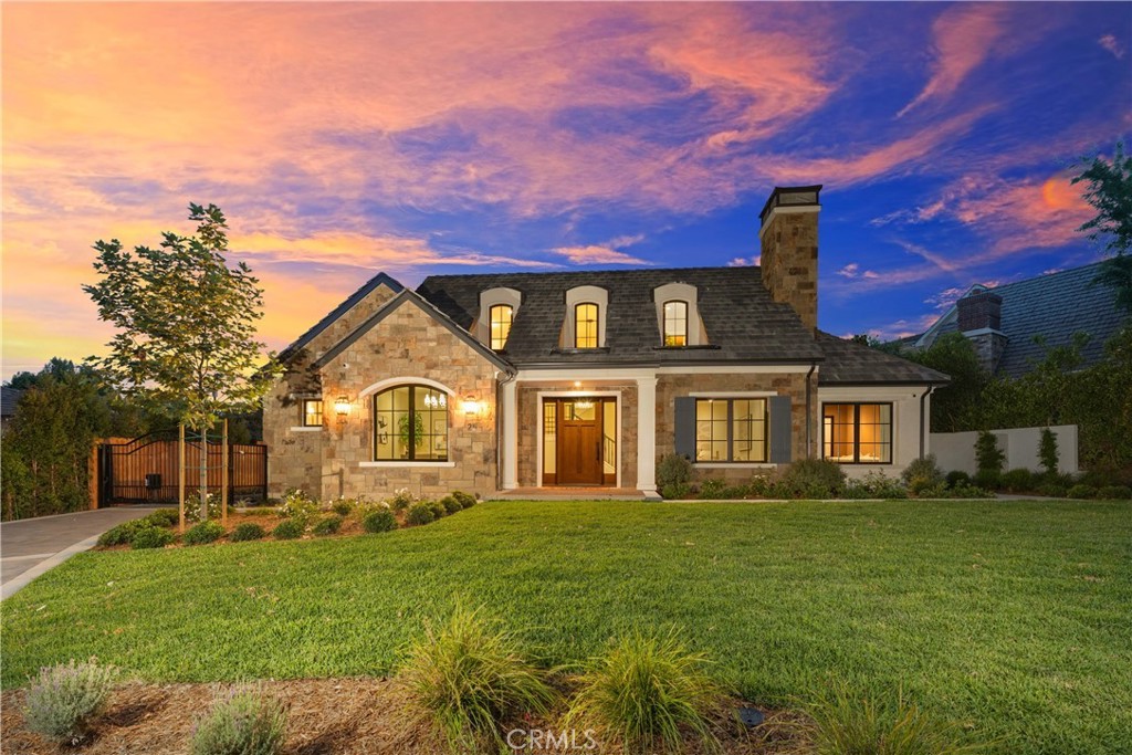 Brand New Construction in Lower Rancho | Modern Elegance Meets Timeless Craftsmanship. A rare and extraordinary opportunity—the only brand new construction offered for sale in Arcadia’s coveted Lower Rancho neighborhood in the past two years. Built by esteemed local builder Tipping Construction and masterfully designed by Rachel Duarte of Design Studio LLC, this home is a true showcase of refined living. A beautiful natural stone façade sets the tone as you arrive, complemented by a gated entry, paver-lined driveway, and elegant architectural lines. Inside, the home exudes warmth and sophistication, with stunning hardwood floors flowing throughout—except for the custom-carpeted home theatre—creating a seamless blend of luxury and comfort. The formal living room and separate dining area provide ideal spaces for entertaining, while the expansive family room features large retractable glass doors that open to a beautifully landscaped backyard. A covered paver-lined patio offers the perfect setting for year-round outdoor enjoyment. At the heart of the home, the gourmet kitchen is both stylish and functional, boasting sleek Thermador appliances, modern cabinetry, natural quartz countertops, and striking black and gold designer accents. The main level includes a richly detailed office with wood floors and a decorative chandelier, a dedicated movie theatre with custom carpeting, designer window coverings, a large screen and projector, and a state-of-the-art 9-speaker surround sound system. Also on the ground floor is a luxurious junior primary suite with an en-suite bath, offering privacy and comfort—ideal for guests, extended family, or multigenerational living. Upstairs, the home features three spacious bedrooms, including the luxurious primary suite, which overlooks the backyard and includes a spa-inspired bath adorned with marble finishes, champagne limestone flooring, and slab shower walls. Two additional upstairs bedrooms offer ample space and comfort for family or guests. Throughout the home, decorative chandeliers hand-selected by the interior designer elevate each space with curated elegance. The attached two-car garage features epoxy flooring, and the home includes paid-off solar panels for energy efficiency. Located in the award-winning Arcadia Unified School District, this one-of-a-kind estate blends new construction quality with Lower Rancho charm—offering the ultimate in modern California living.