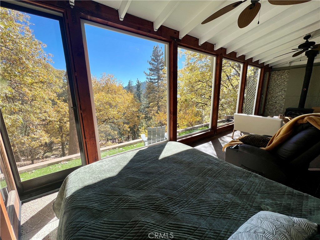 Nestled in the heart of Running Springs, this unique property is designed for those who crave tranquility and modern mountain living. Offering 3 bedrooms, 2 bathrooms, sunroom, three fireplaces, AC and amazing views! Step into the main level with primary bedroom, three-quarter bathroom, and open-concept living area with fireplace that flows seamlessly into the kitchen. The enclosed sunroom with wood burning stove is a standout feature on the main level, bathing the home in natural light and offering panoramic views of the surrounding forest, where towering pines and wildlife create a breathtaking backdrop. Upstairs you will find the additional two bedrooms, one of which has its own fireplace and custom built-in trundle bed. The second level also offers a full bathroom with laundry, and back deck with endless views. Outside, the large parking pad provides ample space for multiple vehicles making this home as practical as it is picturesque. Upgrades include new front retaining walls built in 2024, tankless electric hot water heater in 2022, and AC split units installed in 2020. Whether you’re a weekend adventurer or seeking a full-time mountain sanctuary, this property delivers unmatched charm and functionality. Conveniently located just one street over from local shops and dining, 15 minutes to Lake Arrowhead, and 25 minutes to Big Bear or Highland via Hwy 18 and Hwy 330. Schedule your private tour today and experience the magic of mountain living!