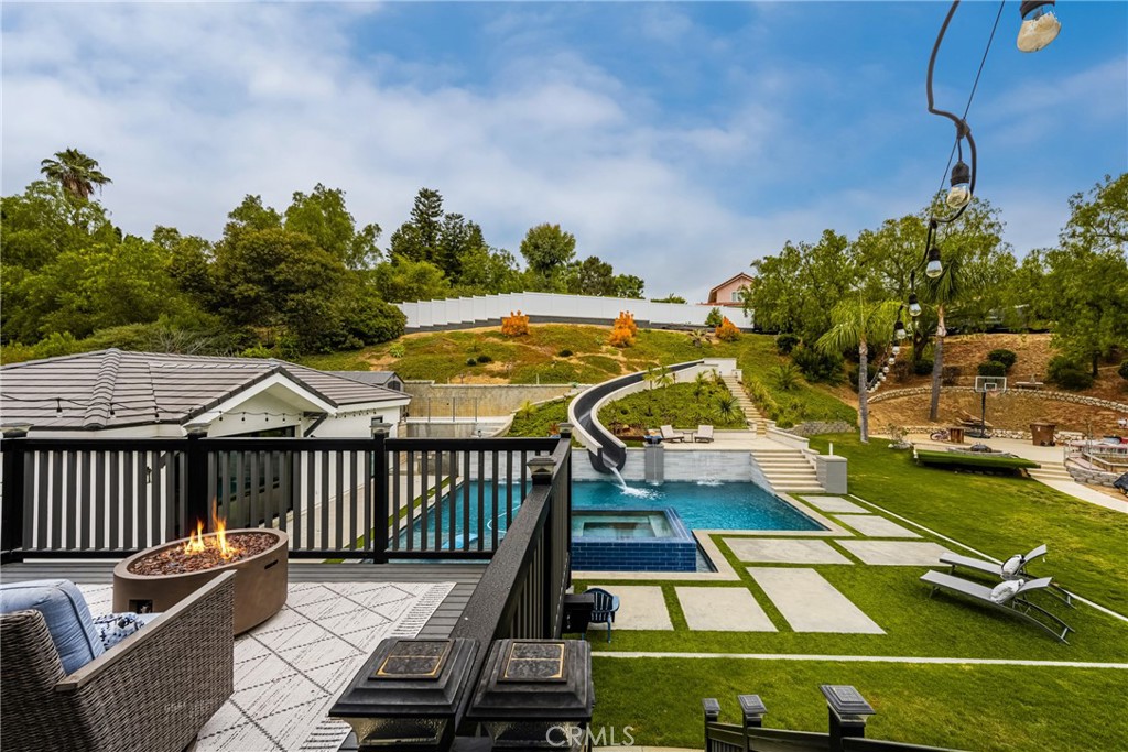 Stunning Turnkey Entertainers Dream Home with Designer Upgrades Throughout!!
Welcome to this impeccably upgraded cul-de-sac residence, featuring a permitted 1,000 sq. ft. guest house with a full kitchen and full bathroom-perfect for guests, entertaining, or multi-generational living. Guest house is included in the main home square footage. The main home showcases a fully remodeled chefs kitchen with a large island, custom fold-out window, ZLINE 6-burner stove with griddle, and a Sub Zero refrigerator. Enjoy seamless indoor-outdoor living with custom La Cantina accordion doors, custom built-in Mont Alpi BBQ station, and a backyard oasis like no other- complete with a custom pool/spa, Baja shelf, 75 ft water slide, water/fire features, new lighting, and an outdoor shower. Recent upgrades include: New roof, owned solar, PEX repipe, and new concrete driveway and patios. Dual zone A/C, newer furnace, whole house fan, and Culligan water filtration system. Remodeled bathrooms and laundry room, recessed lighting, epoxy and hardwood flooring throughout. Custom built-ins in the office loft and living room. Newer smooth texture interior/exterior paint, custom vinyl fencing and wood gates. New lighting fixtures, keyless entry front door, Ring Doorbell, and closet organizers. Custom shutters, remodeled fireplace with built-ins, and deck off the primary suite with direct patio access. 2-3 RV parking spaces with GATED private access at top back of property, built-in garage attic storage, retaining walls, and automated irrigation system. Perfectly blending luxury, function and fun, this home is designed for effortless living and unforgettable entertaining. Don't miss this one-of-a-kind opportunity in one of Yorba Linda's most desirable neighborhoods!