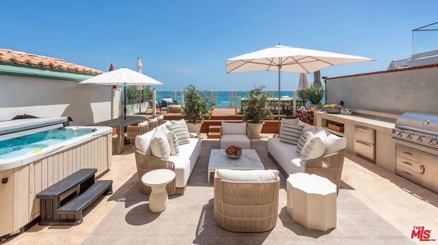 Discover the epitome of coastal living in this Malibu Colony beachfront hideaway. This home boasts beautiful natural light and hardwood floors throughout. With two primary suites featuring panoramic ocean views and two additional bedrooms with mountain views, this home encompasses 4,959 square feet of living space across an open-concept floorplan. The chef's kitchen offers a Wolf range, two sinks, and a large center island ready for cooking or entertaining. The adjacent living room features architectural details, including built-in arched bookshelves. A wall of French doors opens to a sunny deck for effortless indoor/outdoor living. A two-car garage and a deep driveway provide for ample parking. Additional features include a built-in BBQ, wood deck, Jacuzzi, and direct beach access, while Malibu's best shops and restaurants, including Nobu and SoHo House, are just a stone's throw away. Nestled in a 24-hour guard-gated community, security and privacy are paramount. Seize this rare opportunity to embrace the ultimate beachfront lifestyle in one of Malibu's exclusive enclaves.