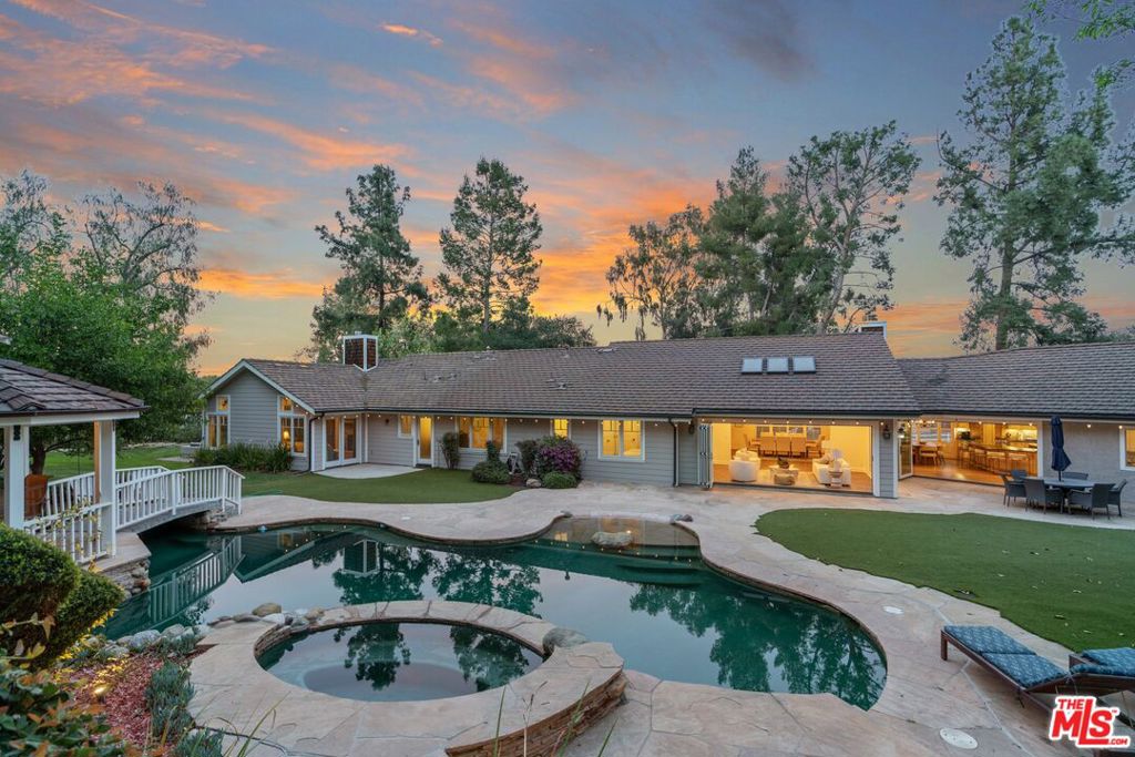 New Price! Situated on an expansive 1.2 acres, this beautifully crafted single-story home with separate guest house is located in the highly sought after neighborhood of Hidden Hills! $1,000,000 in upgrades! The property offers a 6-bedroom, 6-bathroom main house spanning 3,983 square feet of open-concept living. Designed with entertaining in mind, this home features bi-fold patio doors that seamlessly connect indoor and outdoor spaces, opening to a private, spacious yard with a sparkling pool, raised spa, serene gazebo, and a tranquil Koi Pond. The gourmet kitchen is a chef's dream, boasting a spacious island with premium finishes perfect for hosting family and friends. The newly added primary suite is a true sanctuary, featuring vaulted ceilings, abundant natural light, and a luxurious en-suite bathroom with a rainfall shower and jacuzzi tub. The home also features 5 beautifully appointed fireplaces throughout. Equipped with an indoor sprinkler system. Every detail has been thoughtfully designed for comfort and sophistication. In addition to the main home is a charming 557-square-foot, 1-bedroom, 1-bathroom guest house, with separate street access which can be used for a studio, gym, or a source of rental income. Beyond the home, the vibrant Hidden Hills community offers an array of exceptional amenities. Join neighbors at the community center for weekly summer BBQs and a variety of HOA hosted social events. The center features a large pool and spa, tennis, pickleball and basketball courts, a BBQ area, a private theater and recreational room. Horse enthusiasts will appreciate the equestrian facilities, including riding arenas and miles of trails. Guard gated. Don't miss this rare chance to live in a truly special community that combines elegance, leisure, and connection. Make this Hidden Hills treasure your forever home!