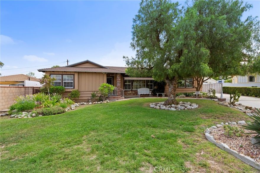 Welcome to this expansive residence in the heart of West Covina, offering a perfect blend of classic character and tasteful updates. Enter inside and discover original hardwood floors that flow throughout the entire home, highlighted by a charming brick gas fireplace and a wall of windows that fill the living room with natural light. The formal dining room features elegant French doors that open directly to the backyard, creating an ideal setting for gatherings. The large kitchen is a chef’s delight with warm oak cabinetry, dark granite countertops, and dual ovens, providing both function and style. A bonus den offers additional living space with a second brick fireplace, a dry bar, and sliding doors leading out to the backyard oasis. The main bathroom is tastefully updated with dual sinks and modern countertops, while the primary suite boasts a private en suite with a glass-enclosed shower and updated flooring. Both additional bedrooms feature built-in storage, and a convenient indoor laundry room comes equipped with extra cabinets. Outside, you can enjoy a covered patio, a sparkling in-ground pool, and a grassy lawn. A rear picket-gated area makes the perfect dog run, while the long driveway and detached 3-car garage offer ample parking and storage. Located behind the garage is a pool changing room ideal for guests as well as a separate rumpus room perfect for use as a hobby room, game room, home gym or office! Set on a massive lot, this home offers incredible space inside and out—perfect for entertaining, relaxing, and creating memories.