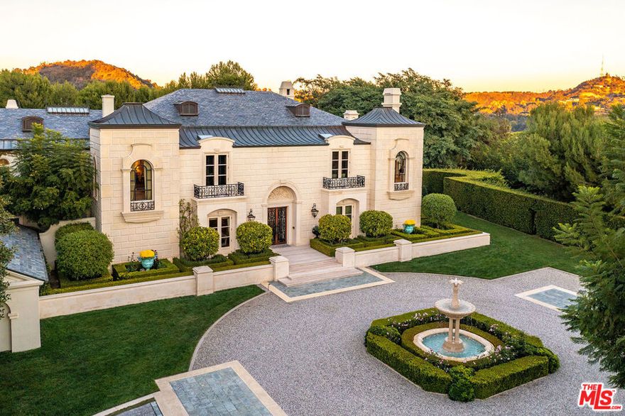 55 Beverly Park offers grand scale living with elegant proportions & holds infinite possibilities for impeccable entertaining and amazing year-round indoor-outdoor living. Located in the exclusive guard-gated enclave of Beverly Park, this very private home was expertly conceived by acclaimed architect Bob Ray Offenhauser, who worked closely with the homeowners to create their sophisticated vision. An air of French Chateau meets Southern California living pervades over the 2.89 acres of romantic French-style garden landscaping. A natural palate of curated lavish finishes and fine materials, including luxurious European imported stone and marble, are showcased in the 7 bedroom, 9 full-bathroom, 3 powder estate. There are 5bds, 7bas & 3 powder in the 14,239sf main house & 2bds, 2bas in the 1,389sf guesthouse. Estate gates open to the drive leading to the grand circular Motor Court with beautiful, tiered marble Fountain. Divine double wrought iron doors open to smooth limestone flooring leading into the soaring gold-leafed domed Foyer with marbled alabaster skylight casting rays below on the dramatic sweeping staircase. Retreat into the exquisite Library appointed with French-style paneled ceiling and walls, marble fireplace, full built-in bar, and custom cabinetry. Entertainers delight in the expansive Formal Dining Room fashioned with vintage hand-painted Asian wall panels, cove ceiling, and custom table with seating for up to 20 guests. Just around the corner the spectacular China Room is outfitted with impeccable custom felt-lined storage for silver, crystal, fine china, and more. The Formal Living Room offers an intimate, glass walled entertaining area that looks out onto the Reflecting Pond, which is dramatically positioned with a marble statue of Dahpne and Apollo. Floor-to-ceiling French glass doors open from both the Living Room and Family Room to the covered Loggia with cozy outdoor fireplace. The impressive, limestone-clad walls in the Family Room feature a striking groin vaulted ceiling, magnificent towering Beauvigny marble fireplace, built-in bar and panoramic walls of glass offering unobstructed views of the inviting 70-foot Swimmers' Pool and picturesque grounds. Sizeable pocket doors connect the Family Room to the amazing gourmet Chef's Kitchen, which boasts a Baking Area, Butler's Pantry, wraparound granite island, generous storage, commercial-grade appliances (including a Walk-In Refrigerator), and a comfortable fireside Banquette Dining Area overlooking the 1,800-bottle Wine Cellar. Just off the Chef's Kitchen is the glass-enclosed Conservatory, adorned with a magnificent custom oval Murano Glass Chandelier, opulent hand-painted fresco ceiling, and incredible indoor/outdoor ambiance. Ascend the stairs to the sumptuous primary suite comprised of a generous sitting room with fireplace, kitchenette, powder room and idyllic terrace with fireplace and serene hillside views. Discerning dual bathroom suites offer spacious walk-in closets, soaking tub, fireplace, office and custom cabinetry. Three additional Guest Bedroom Suites, and a stunning Theater with velvet stage curtain, ornate French ceiling, marble powder room, and kitchenette complete the upstairs. The lush grounds are an outdoor sanctuary with various alfresco dining/lounging spaces, fountains, verdant sprawling lawn, towering trees & rose garden. The large-scale Swimmers' Pool includes a Spa & Wading Pool (great for children) to be enjoyed w/ the Outdoor Kitchen & Built-in BBQ. The estate's additional luxurious amenities include: a championship night-lit Tennis Court, an Elevator, 1bd/1ba Housekeeping Suite w/ kitchen & private patio (in main house), Home Office (or potential future bedroom), & both 2 & 3 Car Garages. The meticulously well-maintained, ultra-private neighborhood park is conveniently located within a very short distance of 55 Beverly Park, offering wonderful walking paths, play areas for children, serene seating & lovely topiary landscapes.
