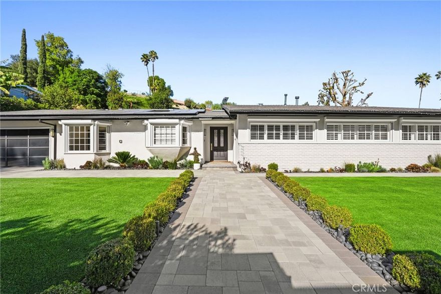 Situated South of the Boulevard in Woodland Hills, this exceptional gated, single-story, remodeled estate offers luxury, privacy, and smart-home living on an expansive 25,000 sq ft lot with a large, private front yard. Spanning approximately 3,700 sq ft, the home features 3 bedrooms PLUS an office and 4 bathrooms with an ideal floor plan. The residence is truly turn-key with extensive recent upgrades including a new roof, new HVAC, new flooring, fresh interior and exterior paint, updated electrical panel, and new lighting throughout. The home offers an open-concept living room and dining room, as well as a large family room, all featuring sliding glass doors that open directly to the expansive, park-like backyard, creating seamless indoor-outdoor living. The home also offers abundant storage throughout, adding to its exceptional functionality. The oversized primary suite includes two large walk-in closets with steel doors and a luxurious en-suite bath. The spacious kitchen features abundant cabinetry, generous counter space, and a breakfast nook. Outdoor amenities include a brand-new pool and heated spa, controllable via phone app, along with a sandy play area ideal for recreation. Both the front and rear yards feature turf for water conservation. Additional highlights include full perimeter walls and fencing, mature Ficus hedging, high-end security cameras, alarm system, blackout security shutters, smart gates and garage, 40 solar panels with Tesla backup battery, and two 240V EV chargers. A rare lease opportunity in one of Woodland Hills’ most desirable neighborhoods.