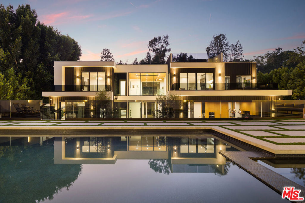 Welcome to 2630 Hutton Dr, a breathtaking architectural masterpiece nestled in the heart of Benedict Canyon. This luxurious home offers an unparalleled blend of modern design and serene privacy, creating a perfect sanctuary in one of the most sought-after neighborhoods. As you step inside, you'll be captivated by the seamless flow of the open floor plan, accentuated by soaring ceilings and expansive windows that flood the space with natural light. The living area opens up to a beautifully designed kitchen, featuring custom cabinetry, top-of-the-line appliances, and a butler's pantry, making it a chef's dream. The primary suite is a true retreat, boasting a private balcony overlooking the meticulously landscaped backyard, a spacious walk-in closet, and a spa-like bathroom. Additional bedrooms are all en-suite, each thoughtfully designed with luxurious finishes and ample storage. Entertaining is effortless with the home's multiple outdoor spaces, including a rooftop deck with stunning canyon views, an outdoor dining area, a fully equipped BBQ with wet bar, and a sunken firepit. The backyard is an entertainer's paradise, featuring a pristine pool and spa, surrounded by lush greenery that enhances the sense of tranquility. For indoor entertainment, the home offers a cozy theater room, complete with an adjacent dry bar and seating area, perfect for movie nights. A well-appointed office, a fitness room, and ample storage throughout add to the home's functionality and appeal. This residence also includes a convenient laundry room with plenty of storage for linens and other essentials. The two-car garage provides secure parking and additional storage space. Experience the epitome of luxury living at 2630 Hutton Dr, where every detail has been meticulously crafted to offer comfort, elegance, and the ultimate in modern living. Don't miss this rare opportunity to own a home in one of the most coveted neighborhoods.