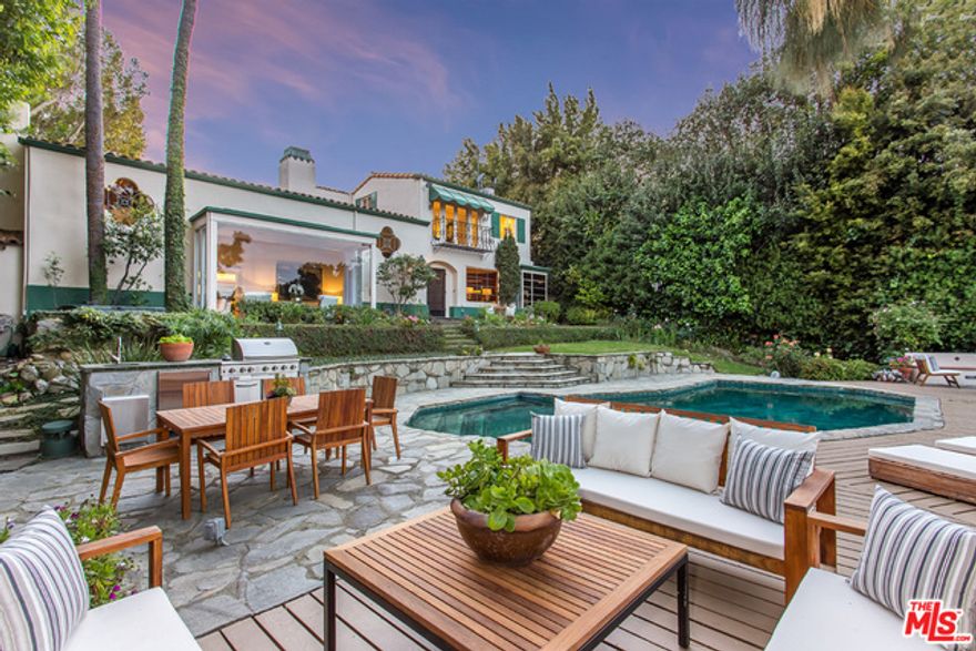 This elegant Spanish Colonial embodies Hollywood glamour at its most romantic- restored and updated to preserve its exquisite details, from cathedral beamed ceilings to wood and terra cotta floors and stained glass windows. Designed in 1932 by architect L.G. Scherer and set on a secluded street in Little Holmby overlooking the LACC, this estate was once home to actress Marlene Dietrich. The entry opens to a loggia overlooking an interior courtyard and leading to a circular 2 story foyer w/ curving staircase. Entertaining areas include a vast great room, anchored by one of 6 fireplaces and a paneled study, both w/ expansive views of golf course and grounds. Adjacent sun rm/den opens to courtyd and flows into spacious game rm. Formal dining leads to remodeled eat-in kitchen.  2nd level has 4 large bedrooms w/ views including master suite and guest rm. Grnd level w/3 car garage, wine cellar. Lush gardens feature paths, pond, waterfall, pool, deck, outdoor fp, bbq. An incredible value!