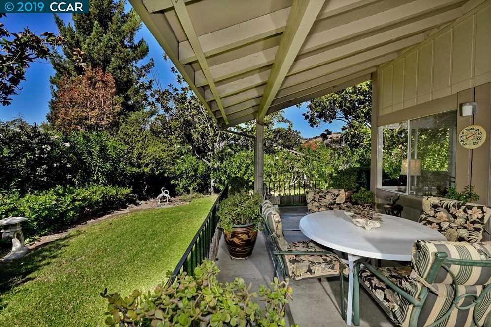 Gorgeous Whitney model condo with private, serene setting at end of street and with only 3 steps to oriental garden entry. Two bedrooms plus DEN with built-in bookshelves. Eat-in kitchen plus formal dining room. Skylights in kitchen and bathrooms. Vaulted ceiling and fireplace in living room. Pristine condition with newer upgraded carpets and custom window coverings. Huge covered back patio with lush wooded setting has feeling of living amid nature. New HVAC system 2016. Attached garage with access from kitchen plus adjacent carport.