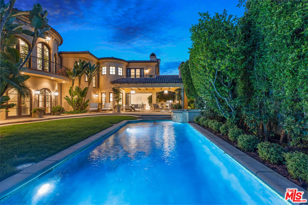 Luxury and design unite in this immaculate Spanish Colonial estate located in coastal Santa Monica. Step inside to find soaring ceilings, designer windows, custom chandeliers, marble and hardwood flooring, and several French doors opening to the grounds, ideal for indoor/outdoor living. The custom chef's kitchen has it all including top-tier stainless steel appliances and butler pantry. Relax in the step-down living room with fireplace, or unwind in the family room with pocket doors leading to the enchanting veranda. The 2nd level primary suite offers a resort-inspired bath, dressing room, and private balcony. 5 additional en-suite bedrooms provide ample space, while an office and study are ideal for remote work. Lounge on the manicured grounds with outdoor kitchen, pool/spa, and basketball/pickleball court. A world-class theater is perfect for screening films and entertaining guests. Just minutes from beaches, this idyllic home offers total serenity in one of L.A.'s most coveted coastal locales.
