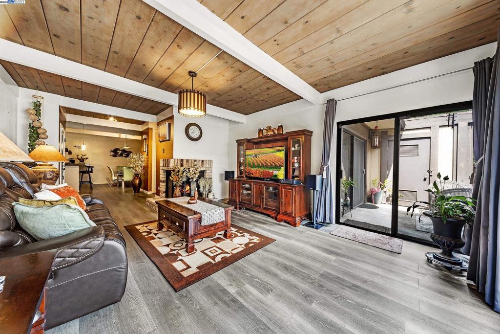 Elegant & Oversized 1BD/1BA Condo in Prime Fremont Location Welcome to 1,221 sq. ft. of refined living in a gated, resort-style community, just steps from Fremont Hub. Step inside to soaring wood beam ceilings, rich laminate and tile flooring, and recessed lighting throughout. The bright, open-concept living room features a cozy wood-burning fireplace and sliding doors that lead to your private patio with tranquil pool views, ideal for relaxing or entertaining. The updated kitchen includes granite counter-tops, stainless steel appliances, and a breakfast bar that flows into a spacious dining area. Retreat to the oversized bedroom with direct patio access, a large walk-in closet, and a second custom closet for added storage. The bathroom offers a double vanity, designer tile floors, and a separate shower/tub area. Additional features include: • In-unit washer/dryer • Dedicated garage parking • Pool access • Peaceful, secure community, minutes from shopping, dining, and I-880. Don't miss this rare opportunity to own one of Fremont’s most spacious and stylish 1-bedroom condo.