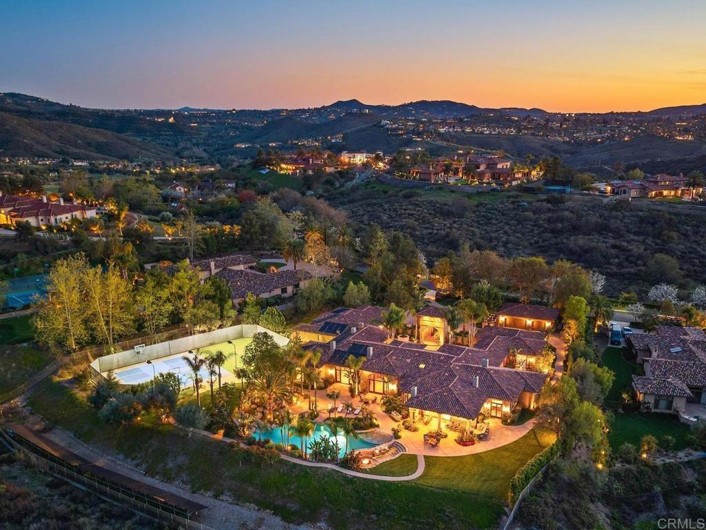 Nestled behind the prestigious gates of The Heritage, this iconic single-level Tuscan estate sits on 5.27 acres of exquisitely landscaped grounds, offering an unparalleled blend of architectural sophistication and resort-inspired living. Originally crafted in 2005 by renowned luxury builder Greg Agee and extensively reimagined in 2023, this grand residence boasts 8,900 square feet of refined interiors, all wrapped around a dramatic courtyard entrance that radiates timeless elegance. The estate showcases five sumptuous en-suite bedrooms in the main residence, a separate guest house (6th bedroom), an executive wood-paneled office, a sleek modern media room, a billiards/game lounge, and formal living and dining spaces designed for grand entertaining. The heart of the home is a chef’s kitchen paired with vaulted great rooms featuring rich beams, custom fireplaces, and seamless indoor-outdoor flow. Outdoors, a private oasis awaits—complete with a multi-level pool featuring waterfalls, grotto, waterslide, elevated spa, and a sunken swim-up bar with fire lounge. For active lifestyles, the estate offers a premier sport park with dual pickleball courts, lighted sports court, and turf play field. Additional highlights include a 6-car garage, smart home features, and proximity to world-class golf, wineries, fine dining, top-tier medical facilities, I-15 access, and San Diego’s renowned coastline. A rare and remarkable offering where luxury, privacy, and lifestyle converge. 3D Virtual Tour + Architectural Floor Plan Available Upon Request