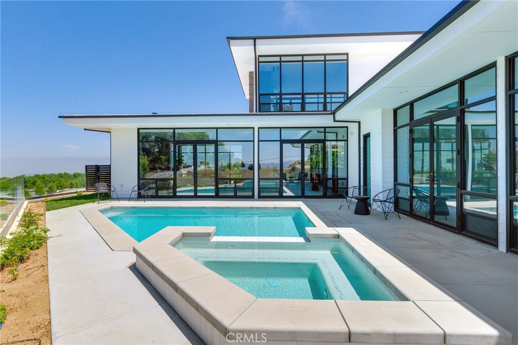 Brand new, contemporary South Redlands pool home on a privately owned, gated street with an oversized three car garage and panoramic views! Completed in 2025, you are greeted by gates when you enter Edgefair Lane, a private community with only three homes. The long driveway leads you up to your private oasis, sitting atop a hill in the center of the community. You enter the home into the great room, with walls of glass on three sides. It sits opposite the tremendous kitchen, featuring an impressive appliance suite, a massive island, and tremendous cabinet space. The custom cabinets include a pop up drawer for a mixer, and a custom drawer next to the range for your cooking spoons. There is also a sizable butlers pantry with an additional sink and a second dishwasher off the kitchen, ideal for catering large gatherings. All three downstairs bedrooms are en-suite with their own private bathrooms. Head up the custom staircase, and you'll find the owners suite - complete with an impressive walk in closet, luxurious bathroom featuring a steam shower and soaking tub, and a service station with an additional sink and wine refrigerator. The bedroom itself features glass walls on three sides, and a private balcony with sweeping views. The attached garage is over 35x23 feet, and features direct access into the home. the pool and spa deck, with glass fencing, can be accessed via the great room, the fifth bathroom, or two of the downstairs bedrooms. Heat and air is provided by top of the line Mitsubishi ductless air conditioners with heat pumps, designed so you only cool the rooms of the home that you are using. Located just off of Sunset Dr. in South Redlands, this location is less than two miles to Redlands Country Club, and ten minutes from downtowns shopping and dining. Excellent Redlands Schools.