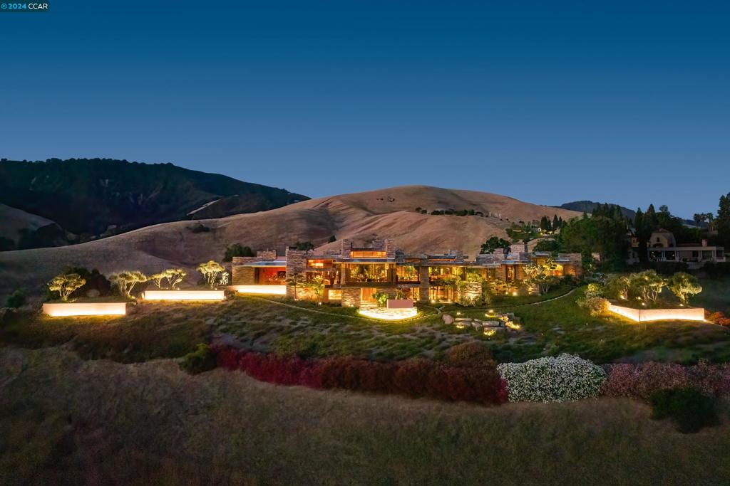 Inspired by Frank Lloyd Wright’s masterpiece Fallingwater, the Behring Estate’s timeless aesthetic enchants. Built for Ken Behring, Blackhawk/R.E. developer, & former owner of the Seattle Seahawks, it embodies the beautiful harmony between nature and the constructed environment, between architecture (Doug Dahlin), interior design (Steven Chase), and landscape artistry (Kimio Kimura). Meander the gardens’ stone walkways amidst waterfalls, gurgling streams, & sculpted greenery. Admire panoramic hilltop views from the refined yet lavish interior, lovingly finished with the finest stone, hardwoods, and glass. As serene as this estate is, it also yearns to be shared. Host family/friends for dinner, games, & conversation on the main level or a poolside bbq under the pavilion. Throw a gala in the estate’s lower-level ballroom and showpiece 10,000-bot. wine cellar and tasting rm. Wake up to framed vistas of Mt. Diablo from the stunning primary suite & start the day under a retractable roof in the indoor-outdoor spa bath. Ultra-private, unmatched luxury near 2 championship golf courses, tennis/pickleball cts, clubhouses, fitness ctr, sprts complex. New house generators. Views: Ridge