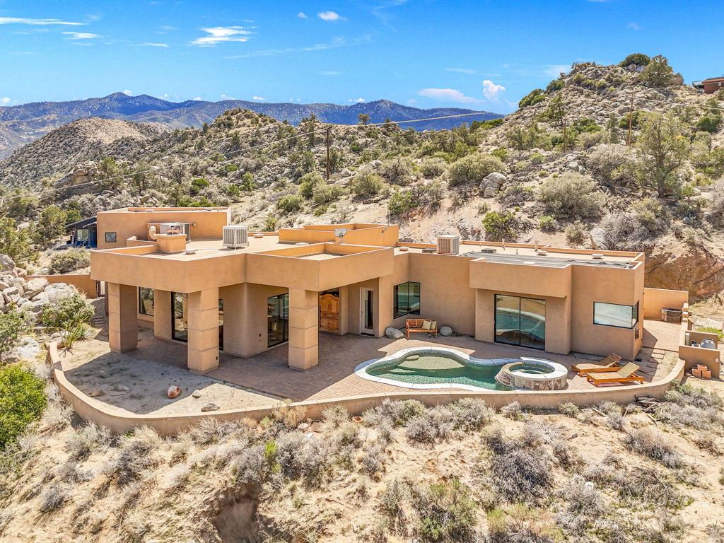 Nestled within the prestigious Pinyon Crest community, this remarkable 3-acre estate combines serene desert living with unparalleled luxury and is located just under 20 minutes from the vibrant El Paseo shopping district. Enter through a tranquil courtyard featuring a calming fountain, leading to an inviting entryway with elegant travertine flooring that flows seamlessly into the expansive living and dining room with cozy fireplace. The open-concept design allows natural light to flood the space, while large windows frame breathtaking valley views.The gourmet kitchen, equipped with top-of-the-line appliances and a stunning granite island, is perfect for the avid chef. Enjoy a primary suite that showcases the same captivating views, complemented by a private entrance, fireplace, beautifully tiled bathroom, and a custom walk-in closet.A second en-suite bedroom, offering its own bathroom and private balcony, is located on a separate level for added privacy.Step outside to the resort-style backyard, where a Pebble Tec pool and spa await, offering the perfect setting to take in the sweeping valley and mountain views. Entertain with ease in the expansive lanai, complete with a fully-equipped outdoor kitchen and firepit.Adjacent to the main residence is an incredible detached guesthouse, featuring its own parking, separate entrance, and a self-contained living space. Enjoy the warmth of hardwood floors, floor-to-ceiling windows, expansive private deck, a full kitchen, bath, beamed ceilings, and stylish, desert-vibe finishes throughout. This exceptional property is ideal for guests or could serve as a high-end rental opportunity.This is truly a private oasis where you can escape the world. Do not let this rare gem slip away, this is a compound you will never want to leave!