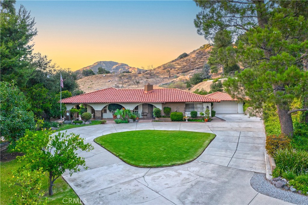 Welcome to 5315 Gaymore Circle, a stunning Spanish-style single-story retreat in the highly coveted Mountain Springs gated community of La Verne. Set on a generous 16,599 sq. ft. lot with no neighbors behind you, this 3-bedroom, 2-bathroom residence offers approx. 2,560 sq. ft. of refined living space designed for both comfort and sophistication. From the moment you arrive, the grand circular driveway makes a striking first impression while offering ample parking for family and guests. A charming courtyard entry sets the tone, leading you into a home filled with timeless Spanish-inspired character and inviting warmth. Expansive living and dining areas are filled with natural light, creating an airy ambiance perfect for everyday living and entertaining. The well-appointed kitchen flows seamlessly into the main living spaces, while the luxurious primary suite provides a private retreat with its own en-suite bath. Outdoors, the wraparound covered patio and tranquil courtyard embody classic Spanish architecture and invite gatherings, alfresco dining, and evenings under the stars. With no neighbors directly behind, the backyard offers an added layer of privacy and serenity, surrounded by the quiet beauty of Mountain Springs. Complete with a two-car garage, spacious layout, and the prestige of one of La Verne’s most exclusive gated communities, this home is more than a residence—it’s a lifestyle of elegance, comfort, and timeless design.